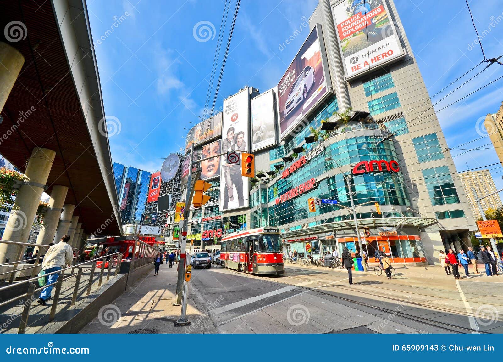 Yonge Dundas Square, With People And Cars Crossing On A Sidewalk
