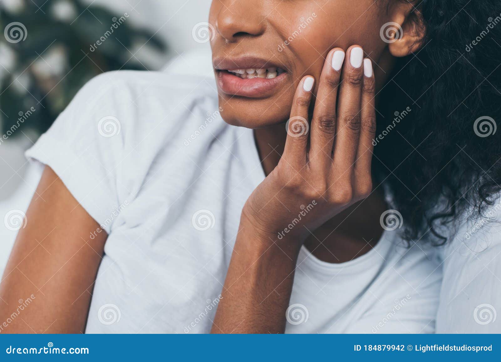 view of young african american woman suffering from jaw pain