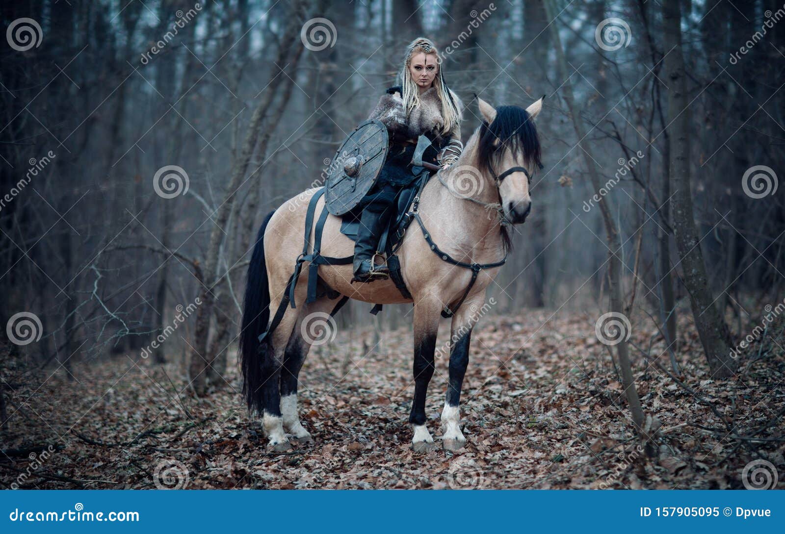 viking warrior female ridding a horse at twilight autumn forest - medieval movie scene