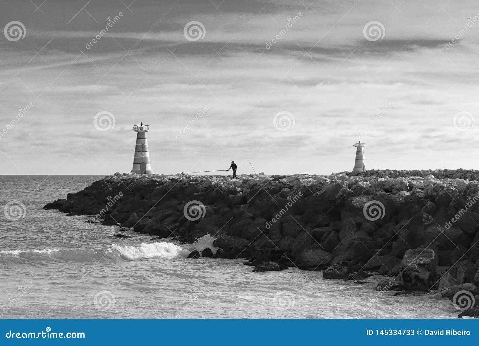 Vilamoura, Portugal - a Man Fishing at the Edge of a Rocky Pier Near ...