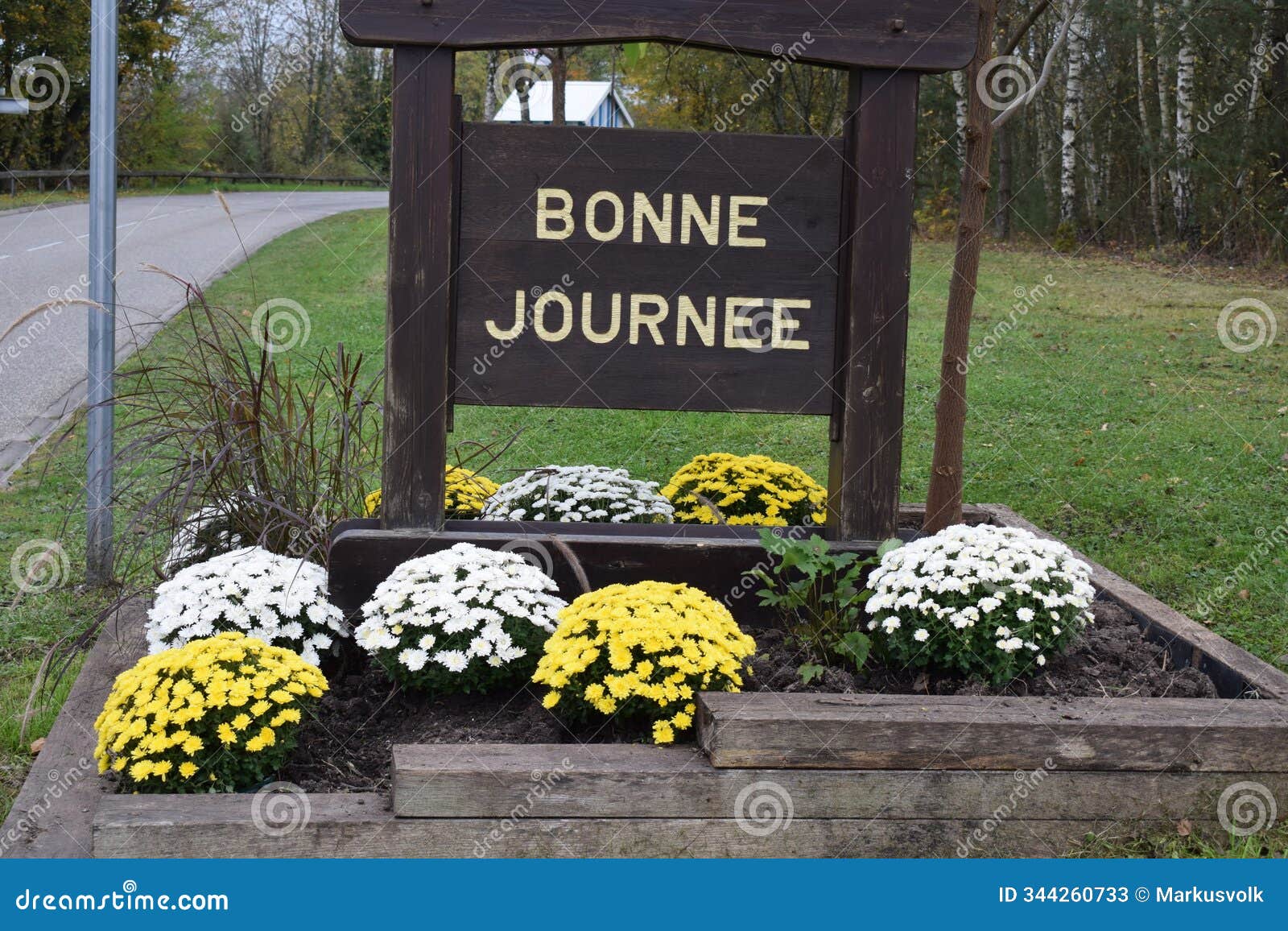 a village exit sign with flowers, bonne journee