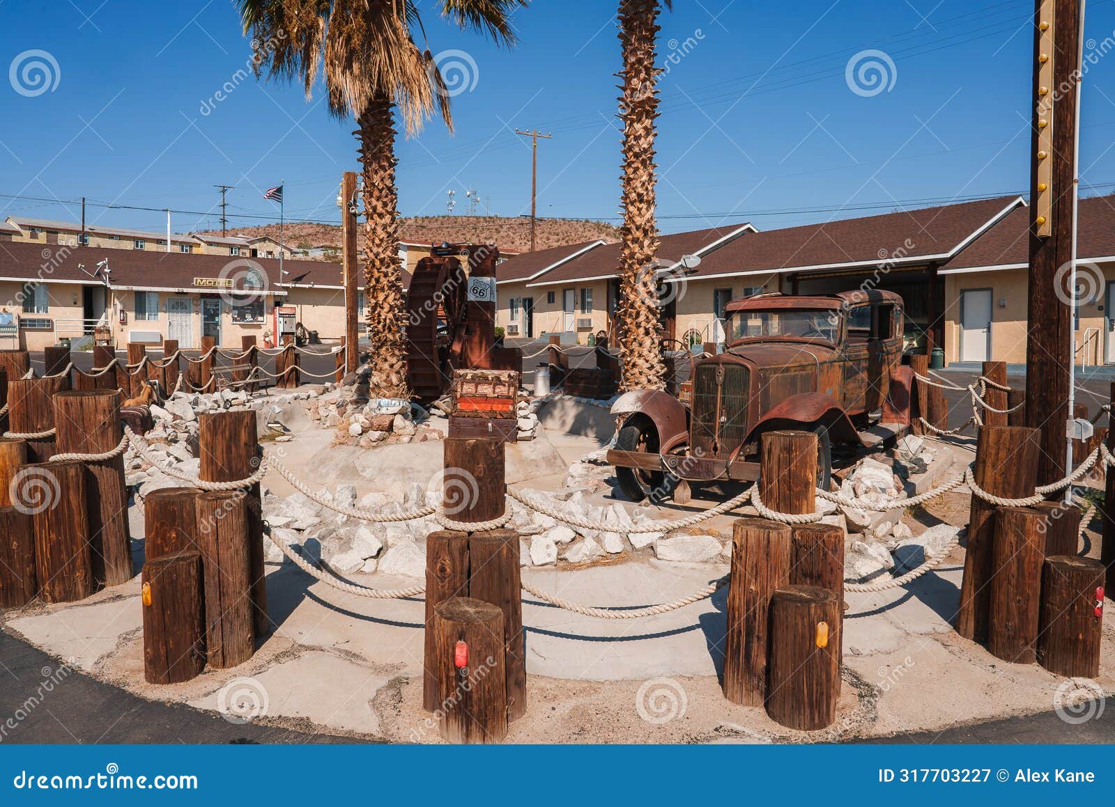 vintage americana rusty wheel and palm trees in barstow, usa