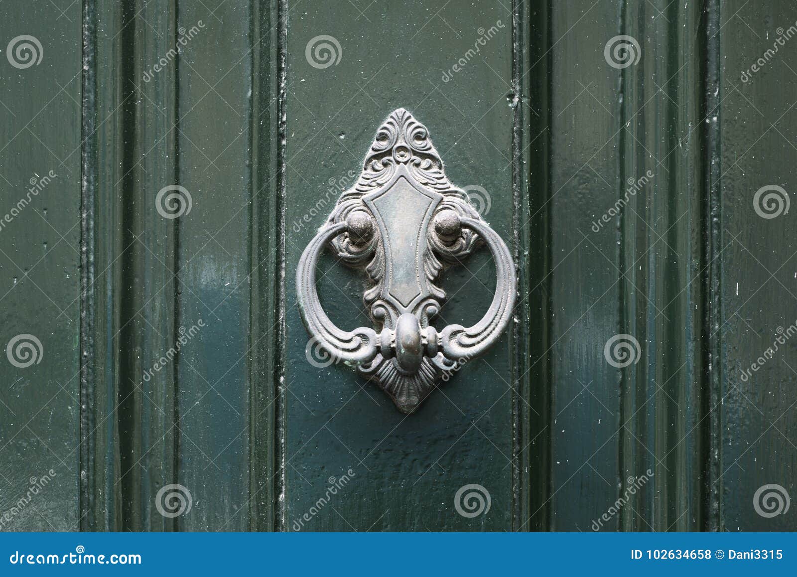 vintage antiqued door knocker on wooden green door