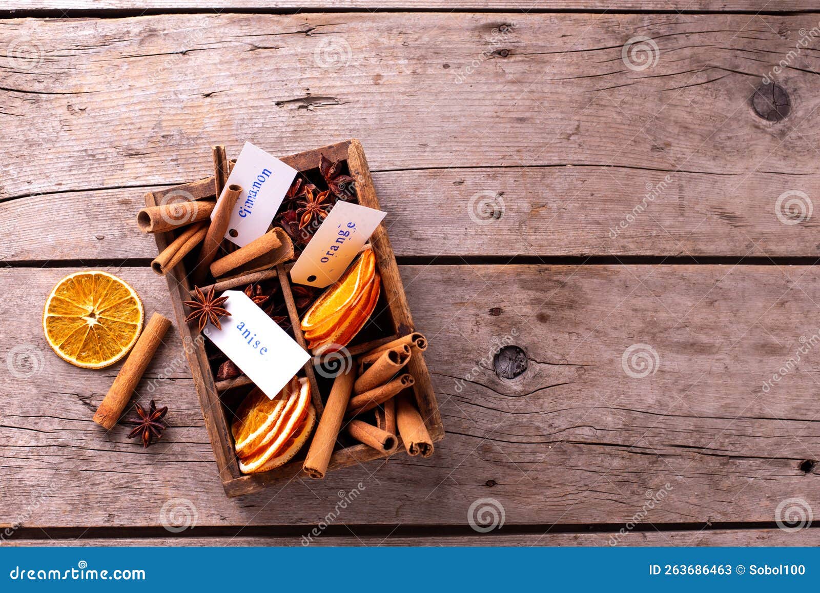 vintage box with  different spices - cinnamone, slices of dried orange, anise on vintage wooden  background.