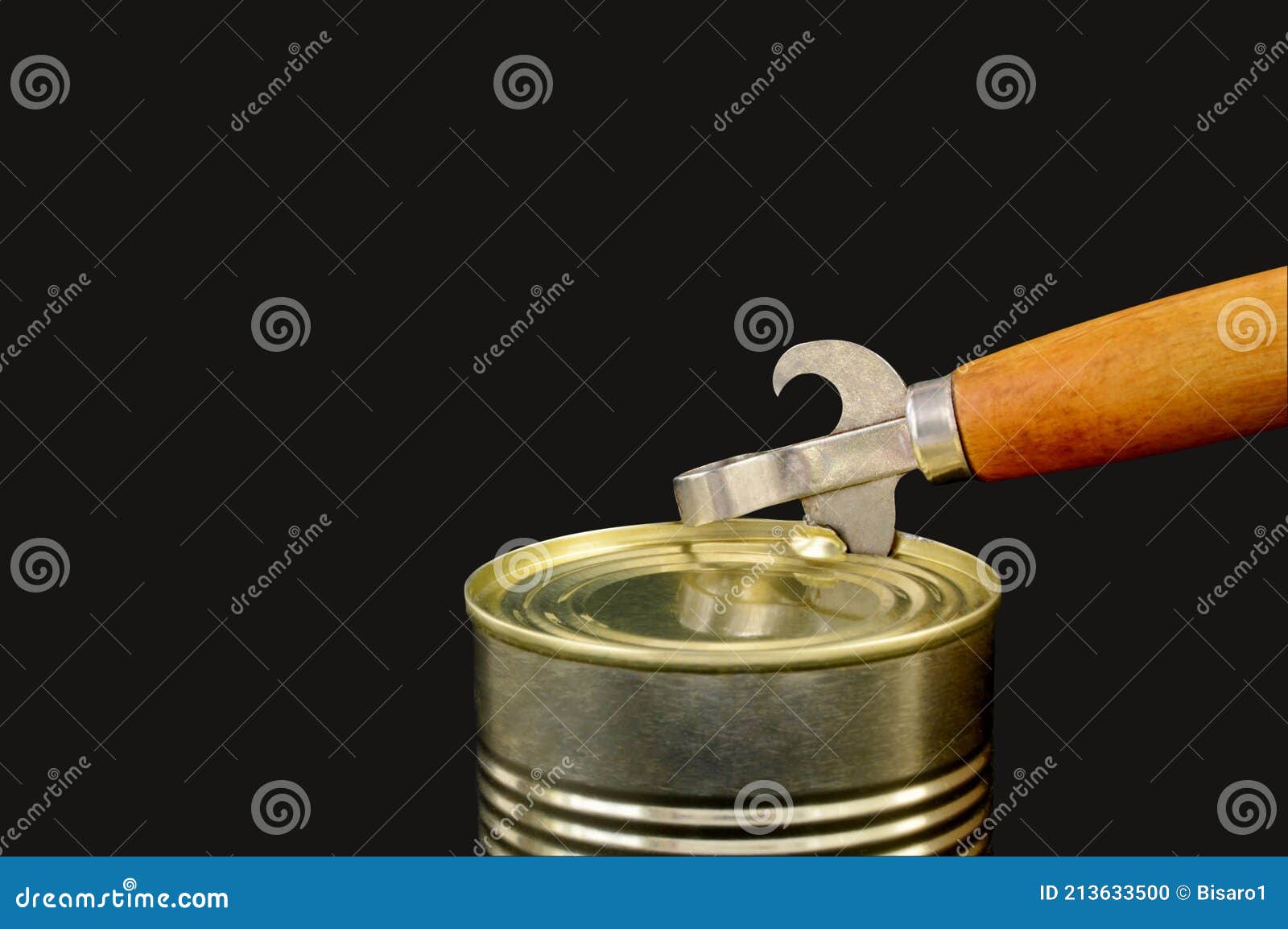 Old style tin opener opening a can, isolated on white background
