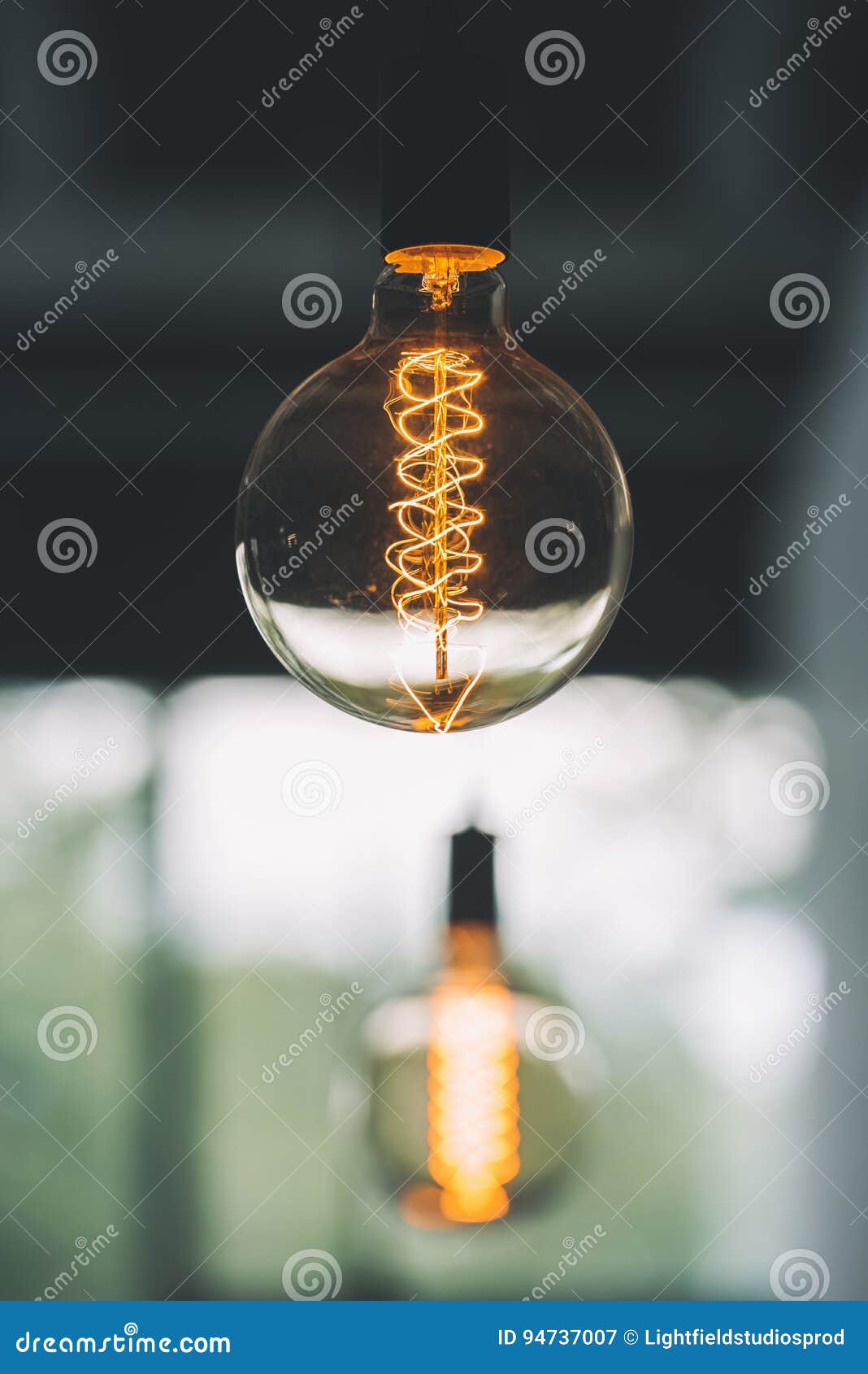 Vintage Edison Light Bulb Hanging with Other Light Bulbs Indoors Stock