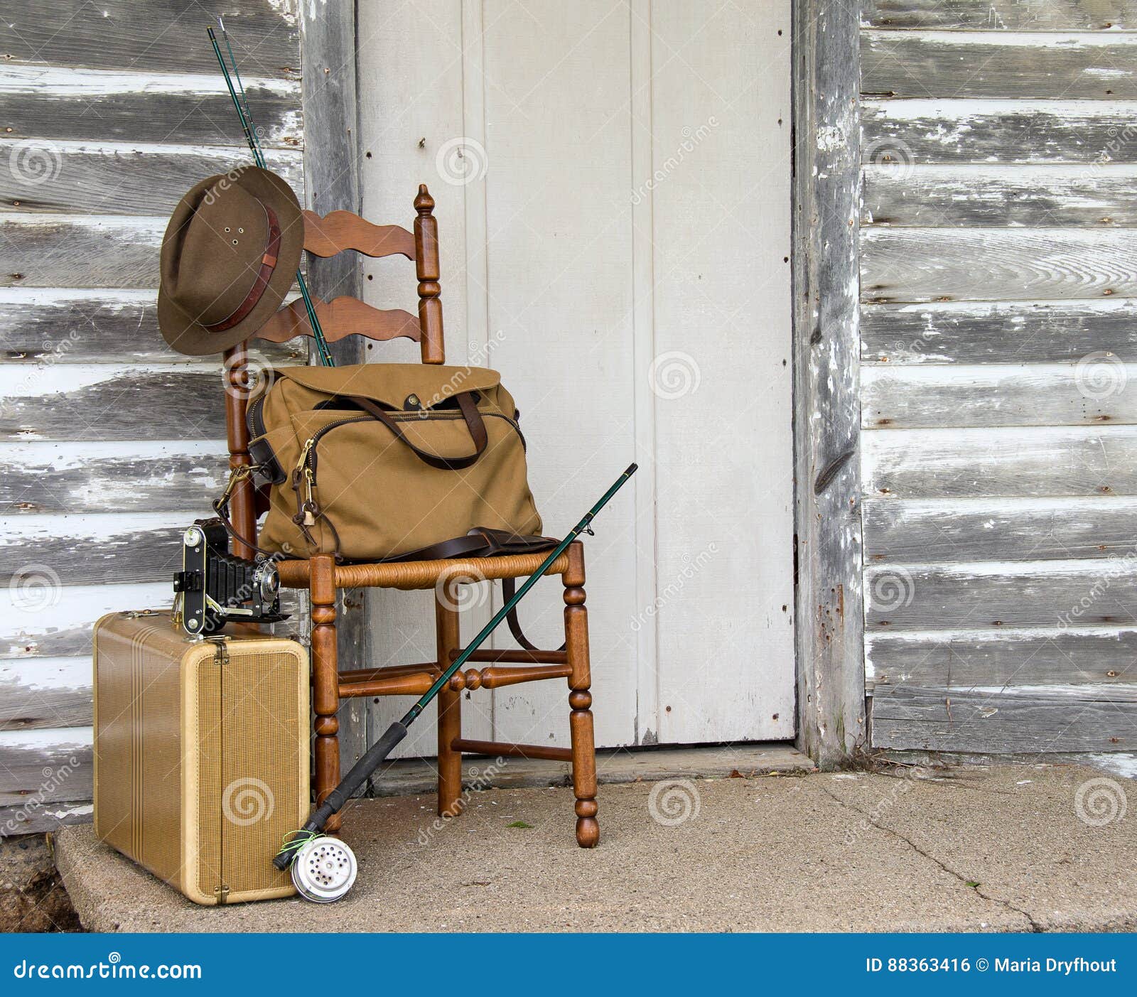 Vintage Fishing Pole with Suitcase on Chair Stock Photo - Image of