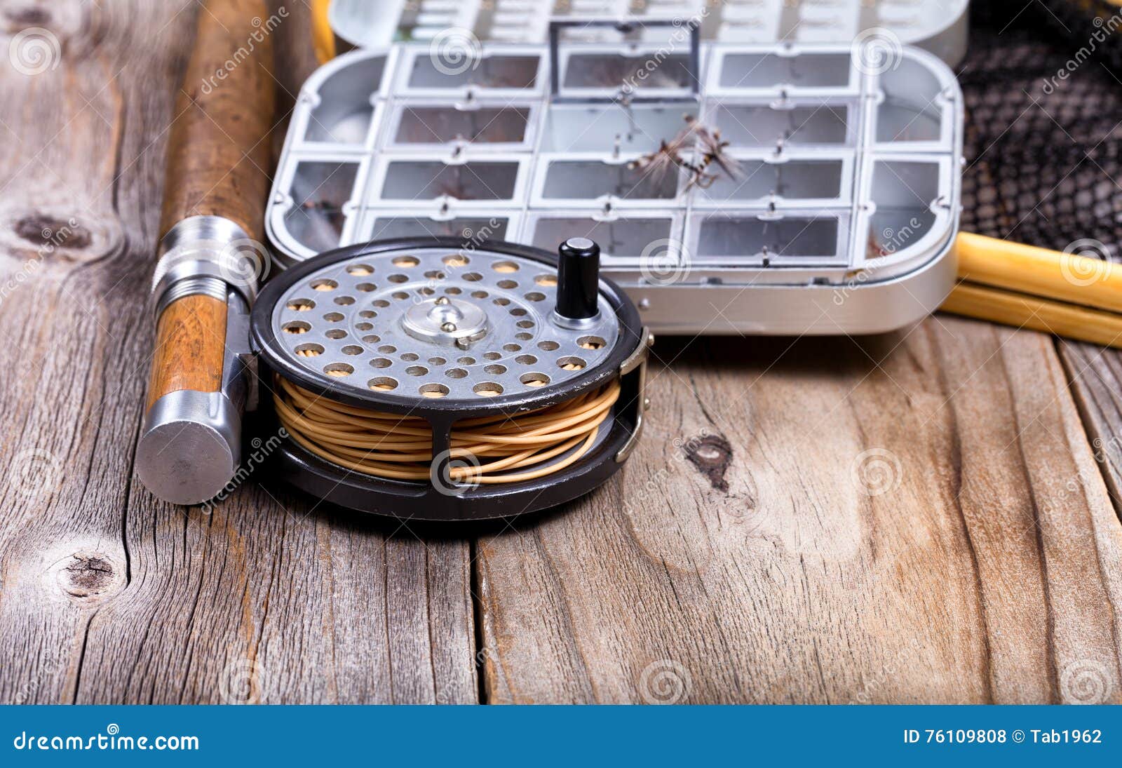 Vintage Fly Fishing Reel and Gear on Rustic Wooden Background