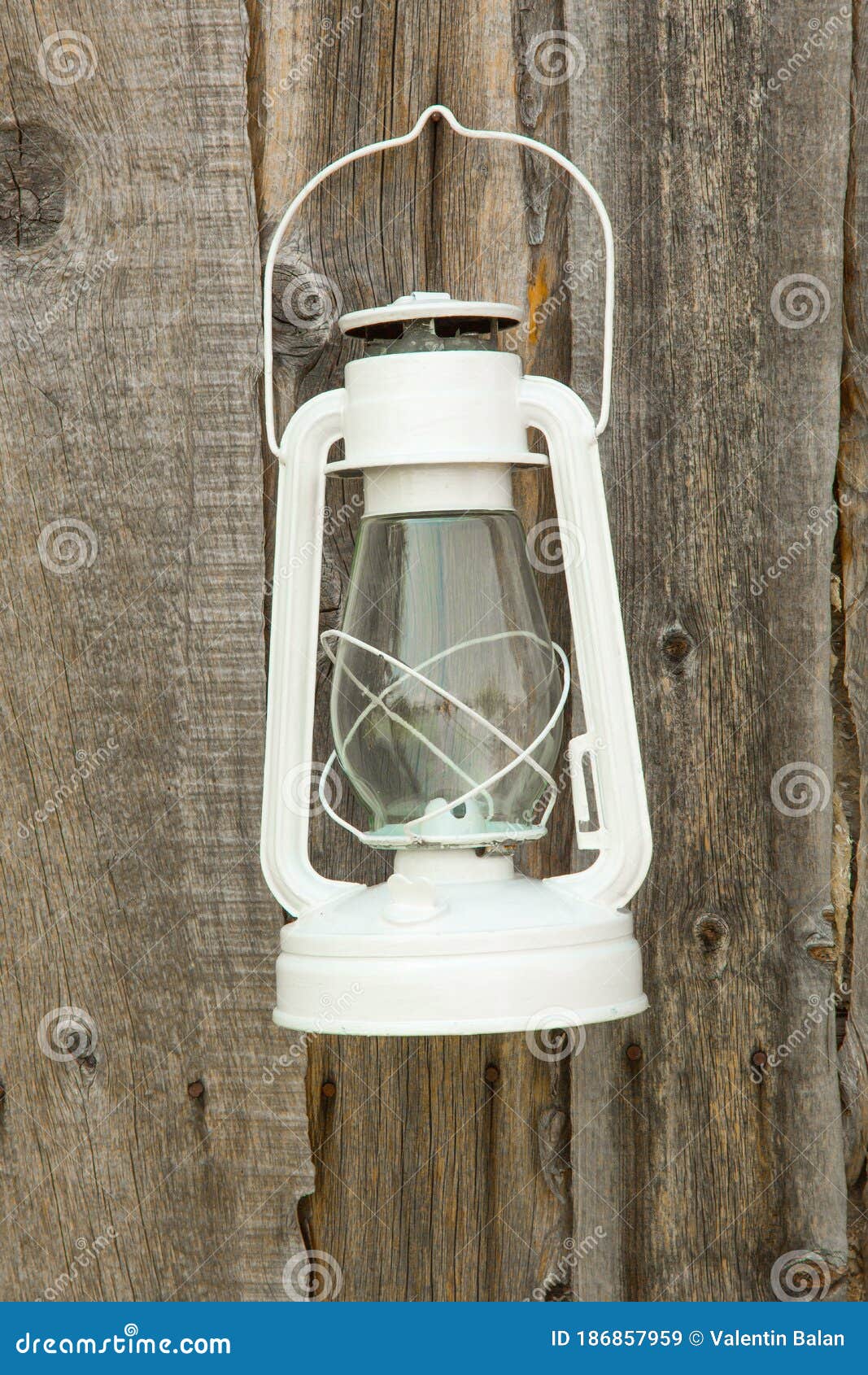 A Old Rustic Oil Lantern On A Wood Block At A Camping Site Stock