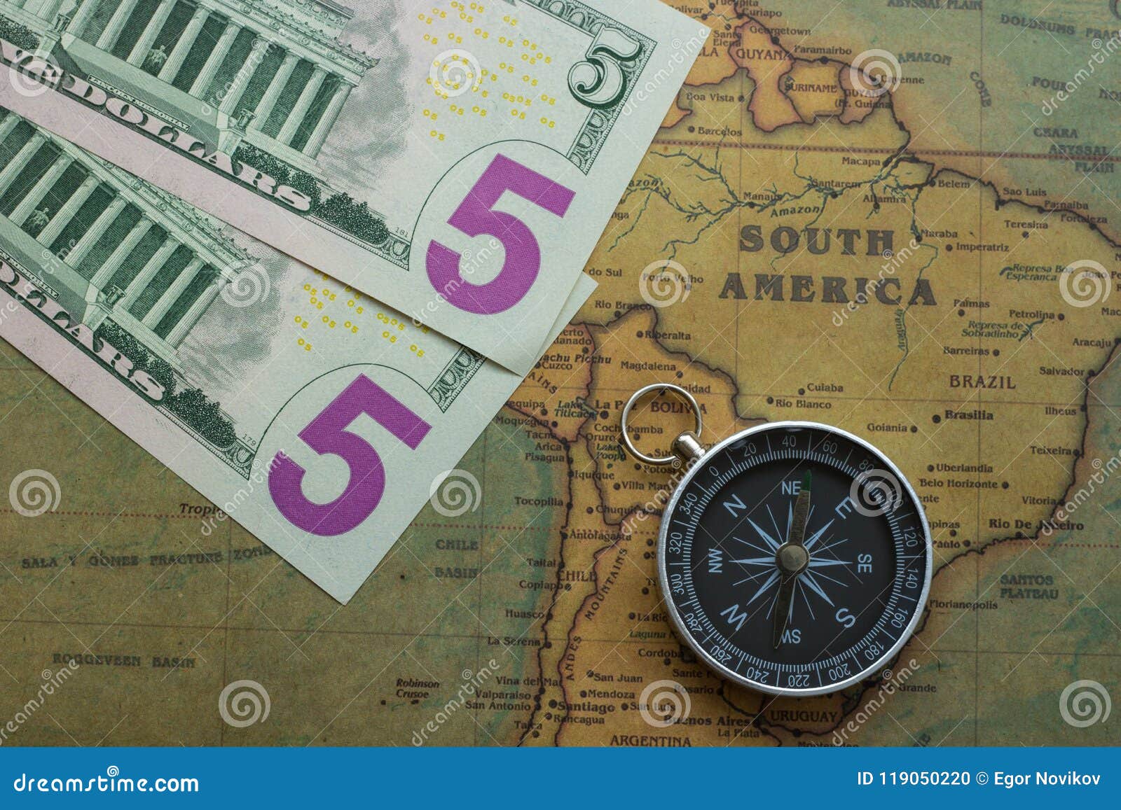 vintage map of south america with five dolor bills and a compass, close-up
