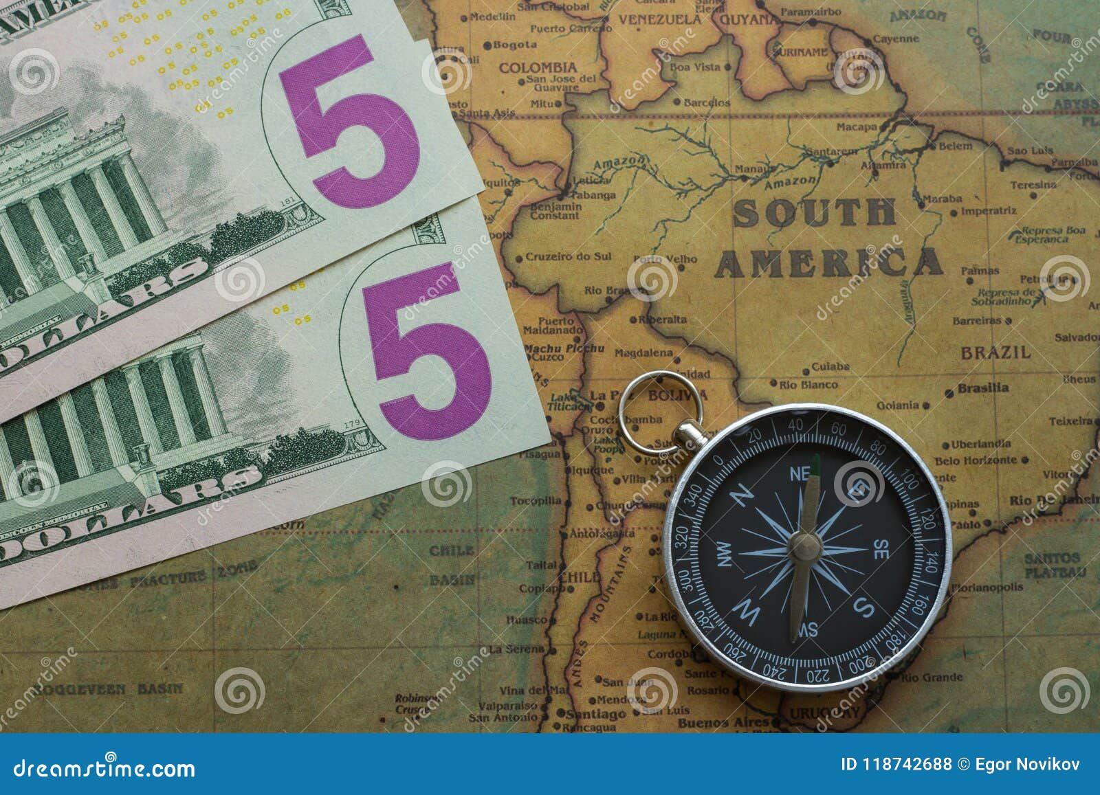 vintage map of south america with five dolor bills and a compass, close-up
