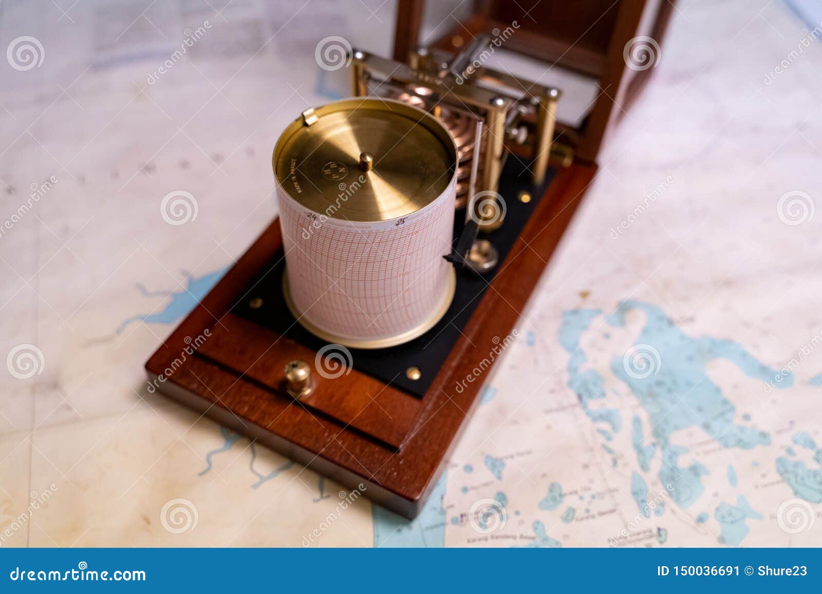 vintage marine barograph with opened cover standing on a navigational chart