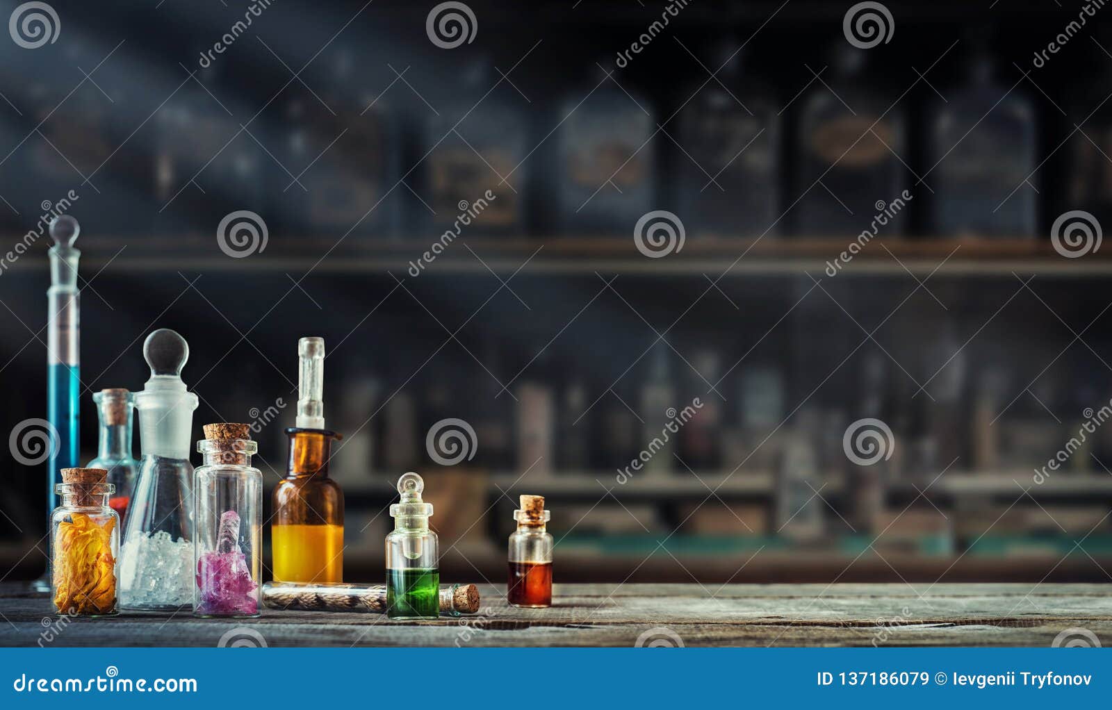 vintage medications in small bottles on wood desk. old medical, chemistry and pharmacy history concept background.