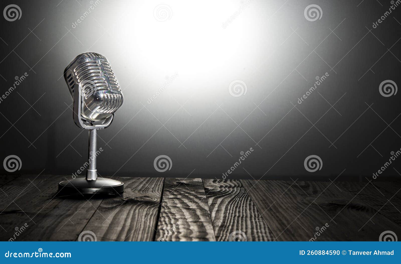 vintage microphone on dark table and bright background - vlog and content creation concept