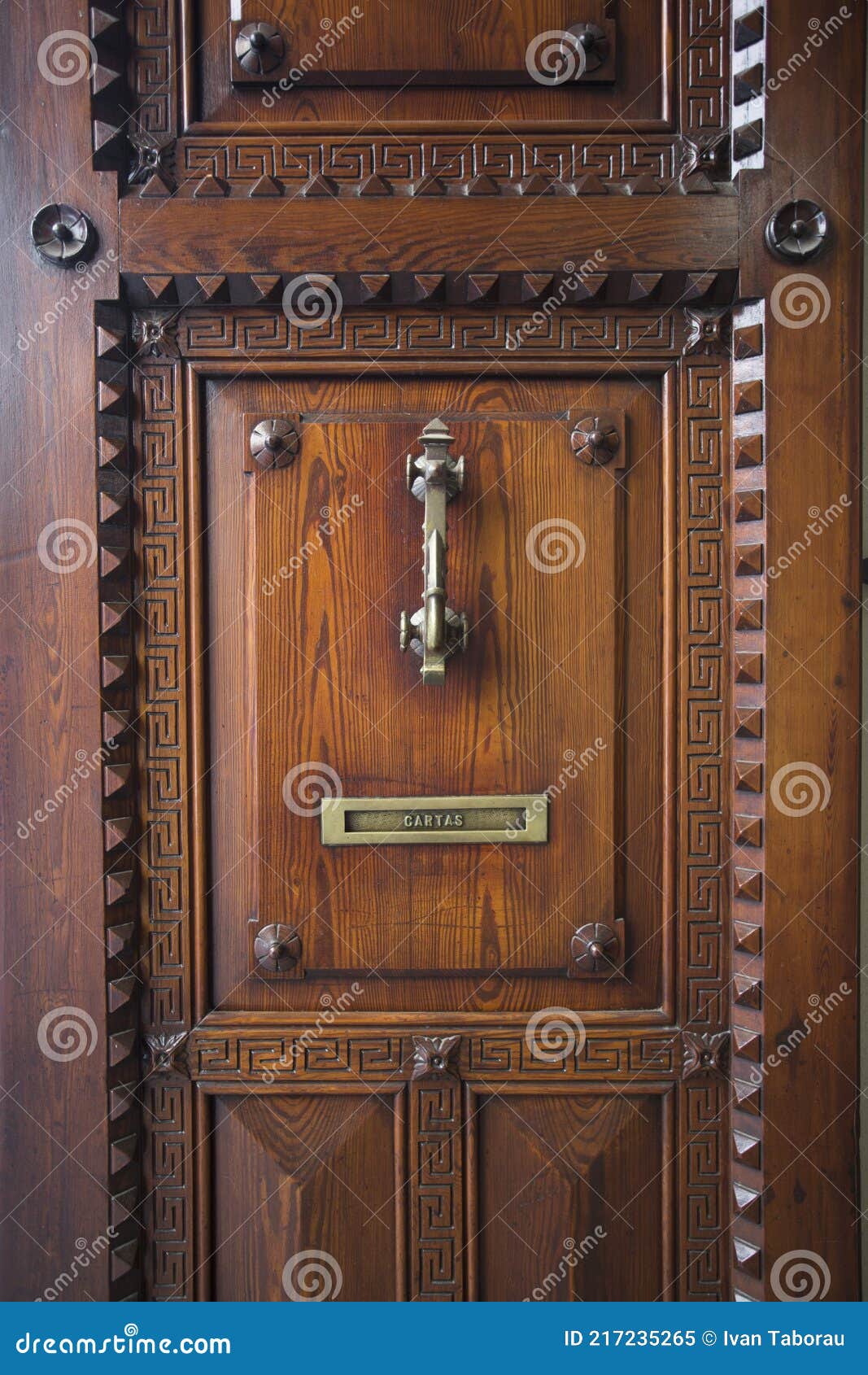 vintage oak door in spain with knock knob and mailbox labeled cartas