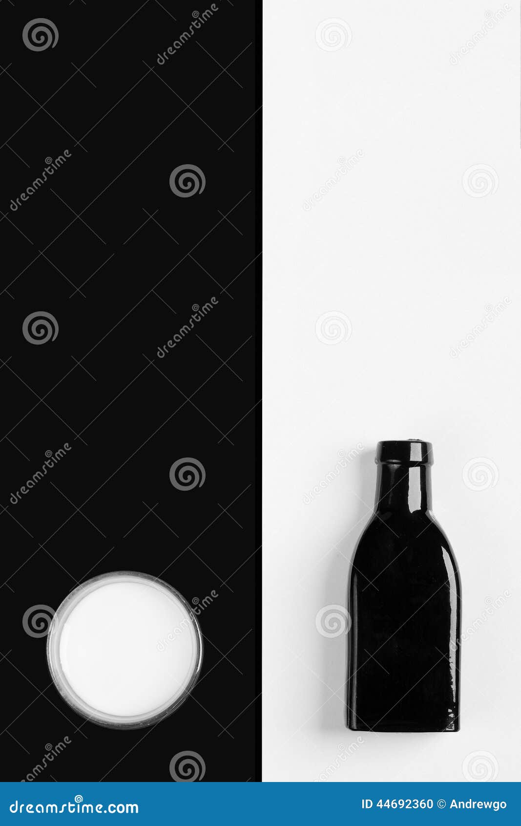 Vintage poucas garrafa e taça pretas do leite em um fundo preto e branco