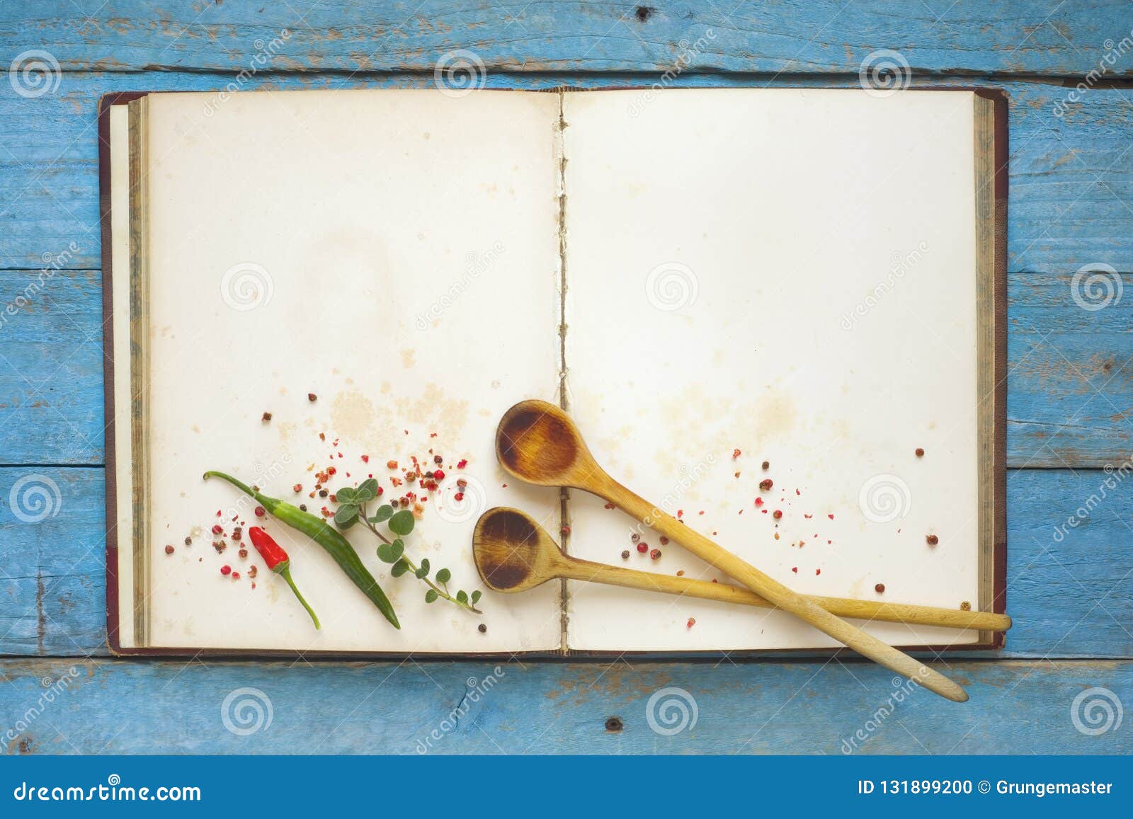 vintage cookbook with empty pages, spices and wooden spoons