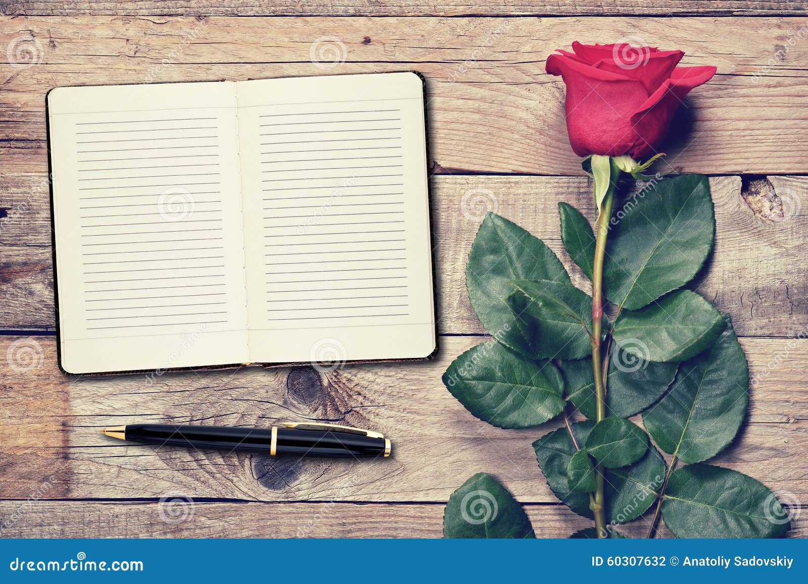 Vintage rose and diary on wooden background