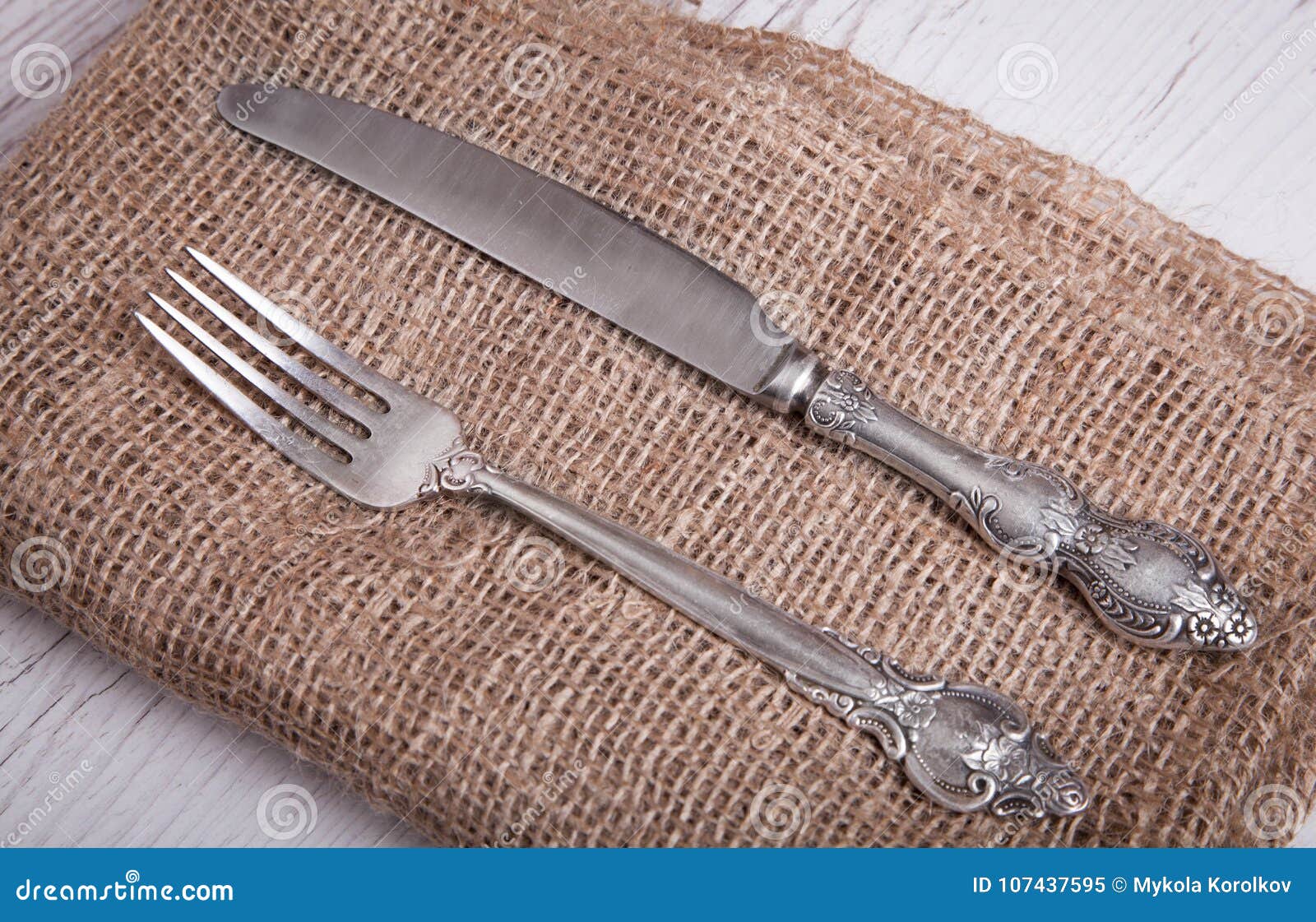 Vintage Silver Tableware Knife and Fork is on Napkin, on an Old Stock