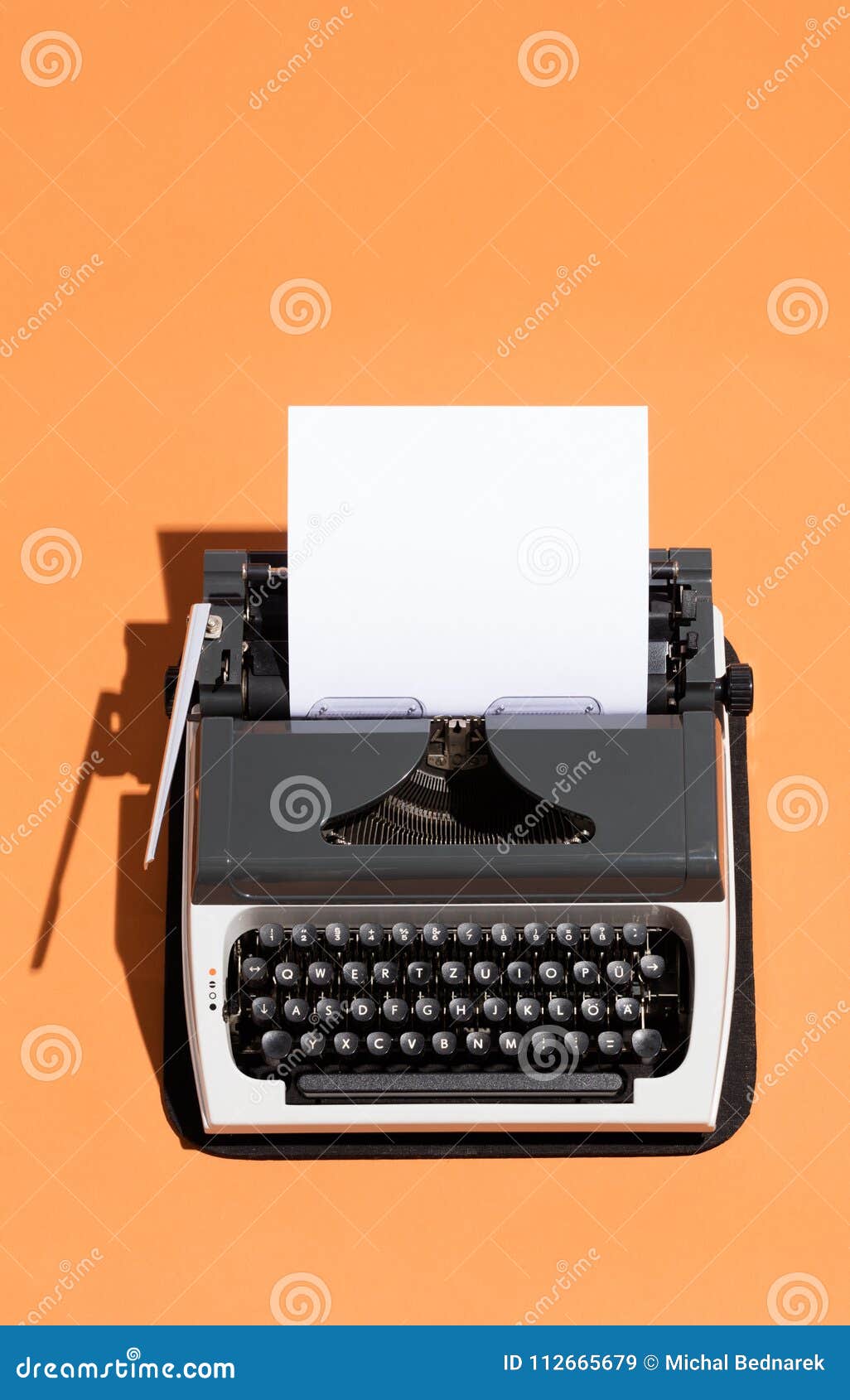 Vintage typewriter with a white blank page