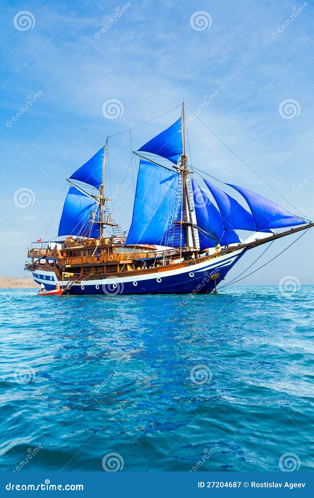 vintage wooden ship with blue sails stock image - image of