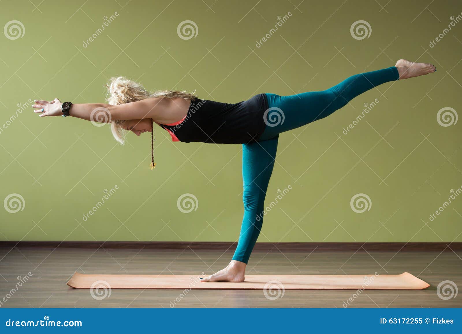 woman making a Yoga pose: Balancing Stick Pose – Tuladandasana Stock Photo