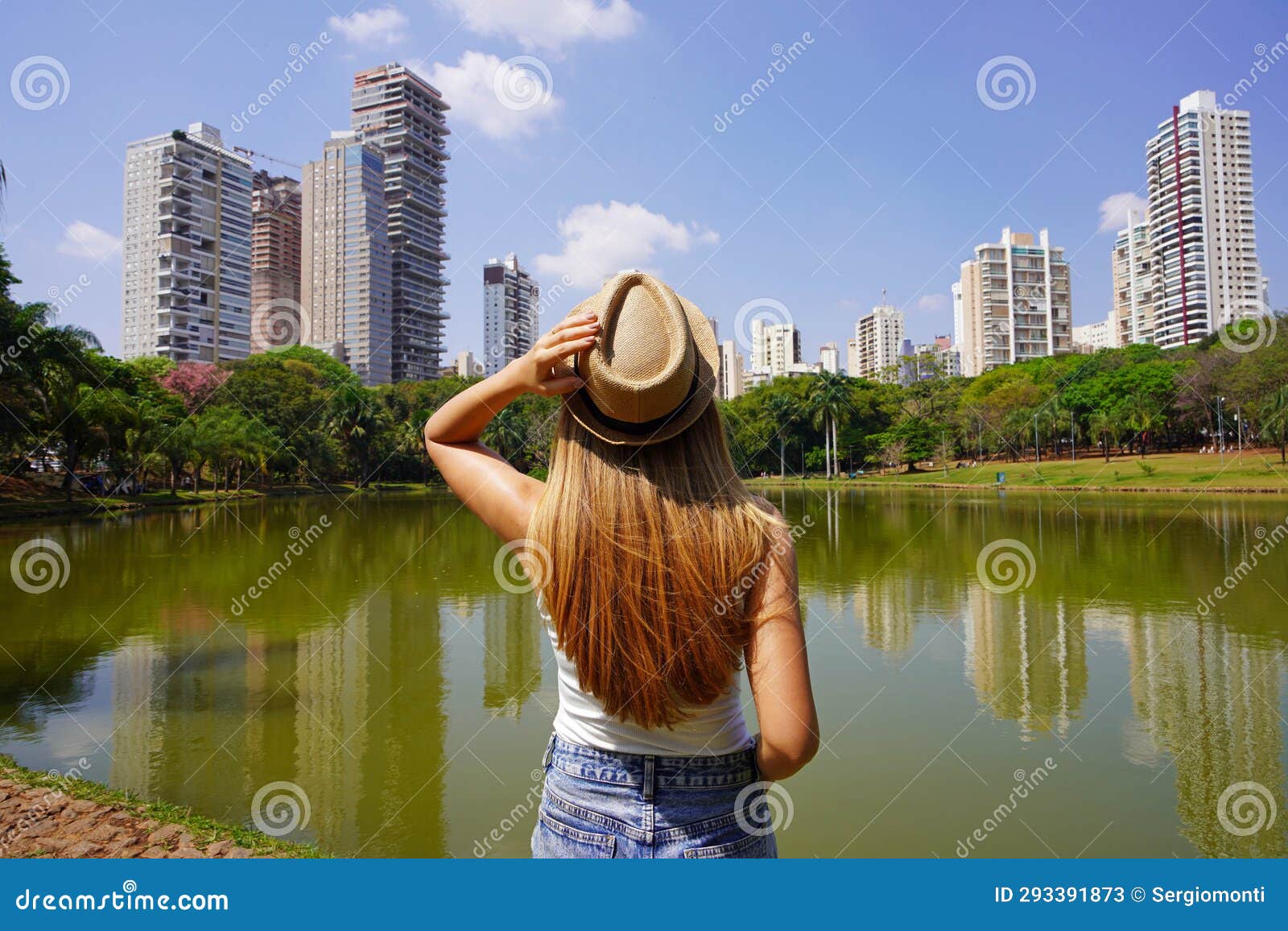 visiting goiania, brazil. back view of young woman in parque sulivan silvestre also known as parque vaca brava, a city park in