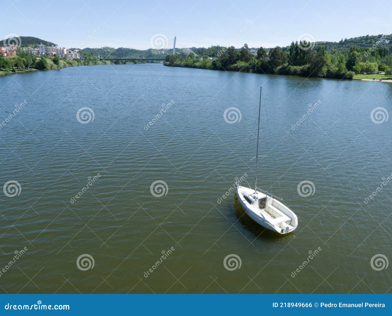 vista de cima do rio mondego em coimbra com pequeno veleiro no canto inferior direito.