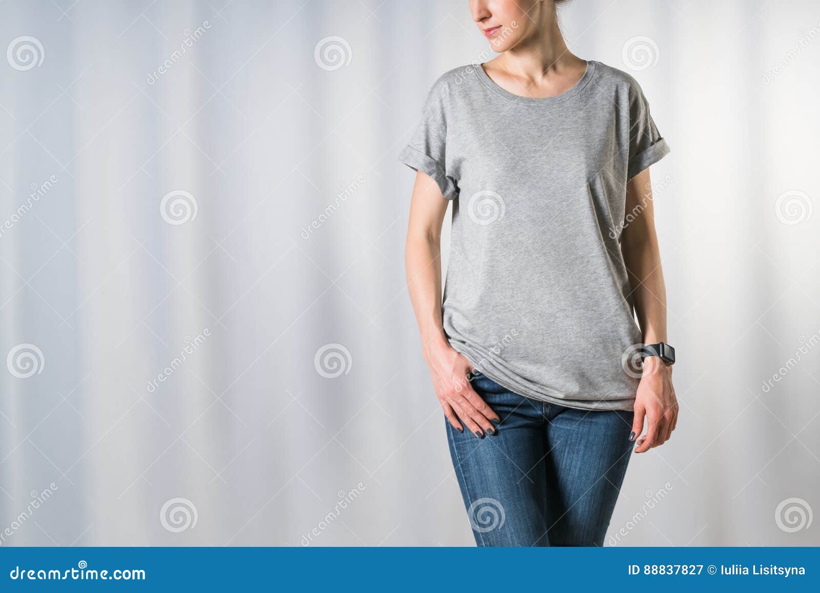 Vista Delantera De La Mujer Joven, Vestida Camiseta Gris Clara Y Los Tejanos, Colocándose En Fondo Gris Imagen de archivo - Imagen de modelo, mano: 88837827
