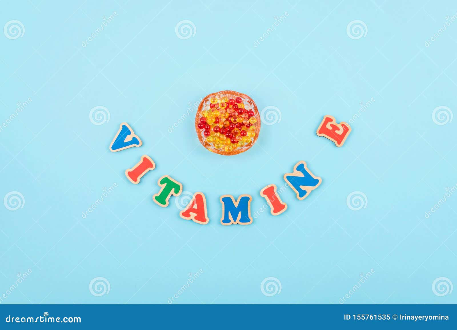 Vitamin E Word Colored Wooden Letters on Blue Background Stock Image