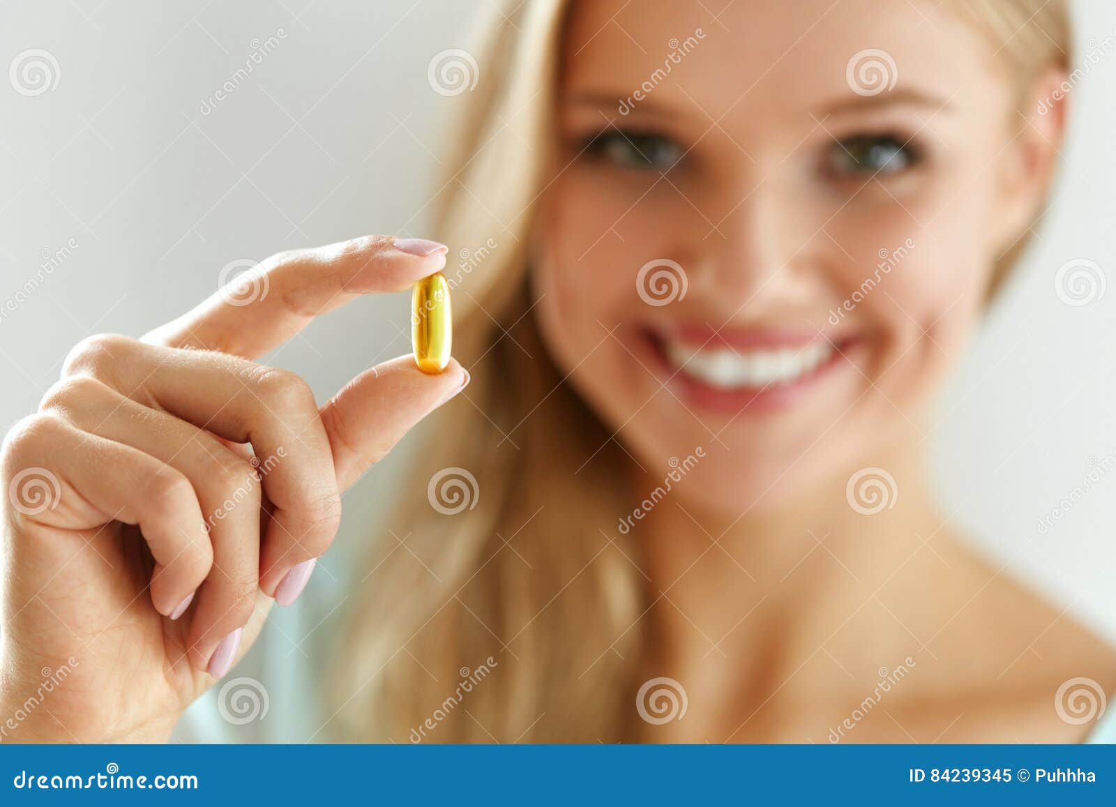 vitamin and supplement. beautiful woman holding fish oil capsule