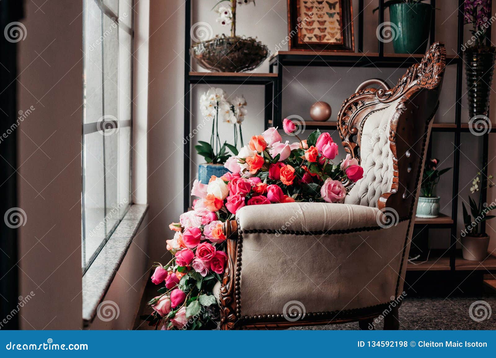 a vitrine from a flower shop with chair and flowers