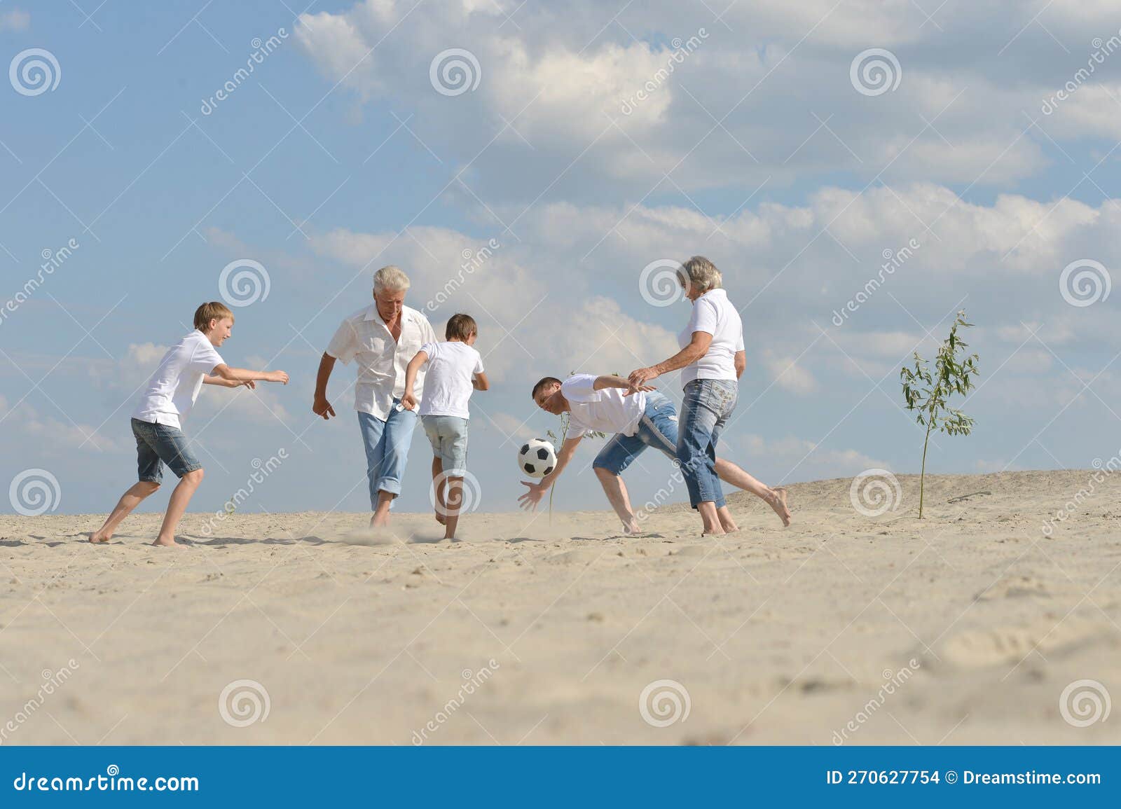 Voetbal op het strand in de zomerdag