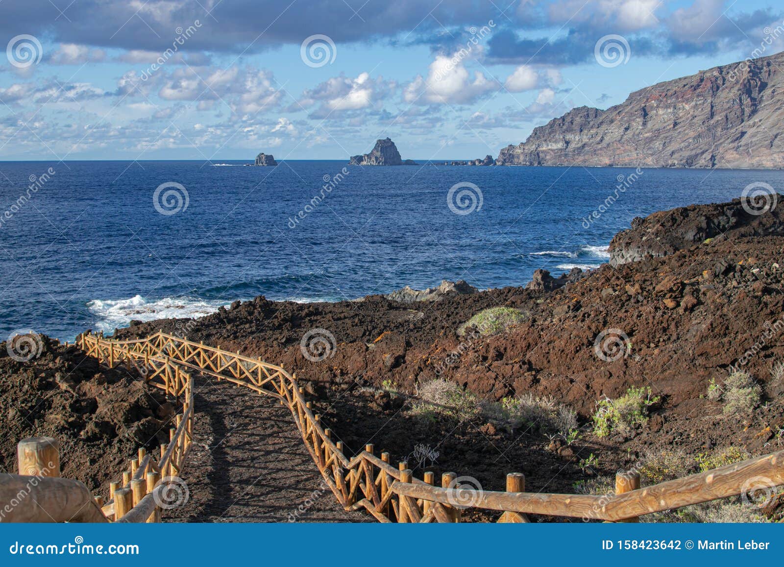 volcanic pathway with wooden railing, with roques de salmor background