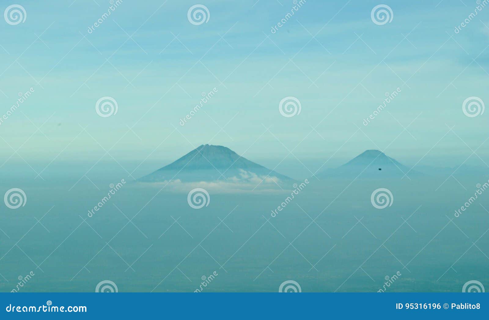 Volcaones Sumbing und Sindoro in Jawa Tengah. Sichtbarer durchgehender Morgennebel der vulkanischen Kegel von Merbabu-Vulkan