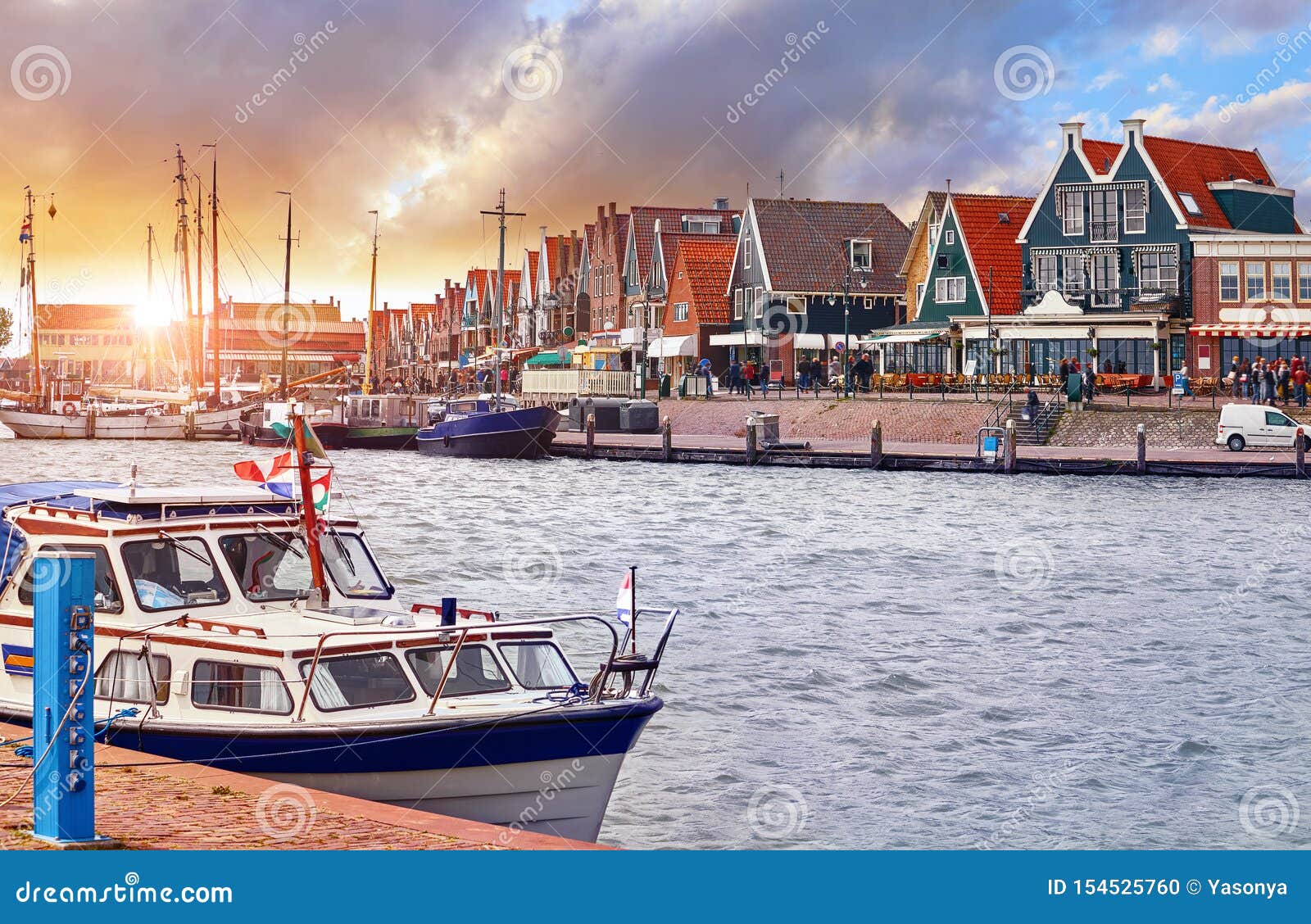 volendam, netherlands. luxury yacht parked by pier on sunset