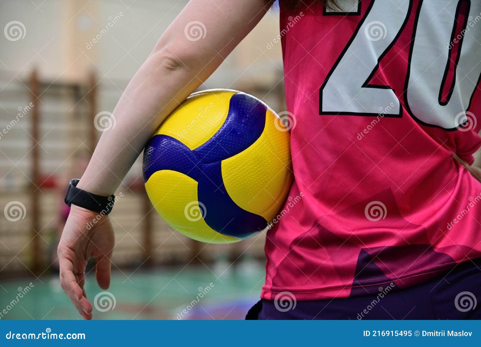 A Volleyball Player Stands with Her Back To the Camera Holding a ...