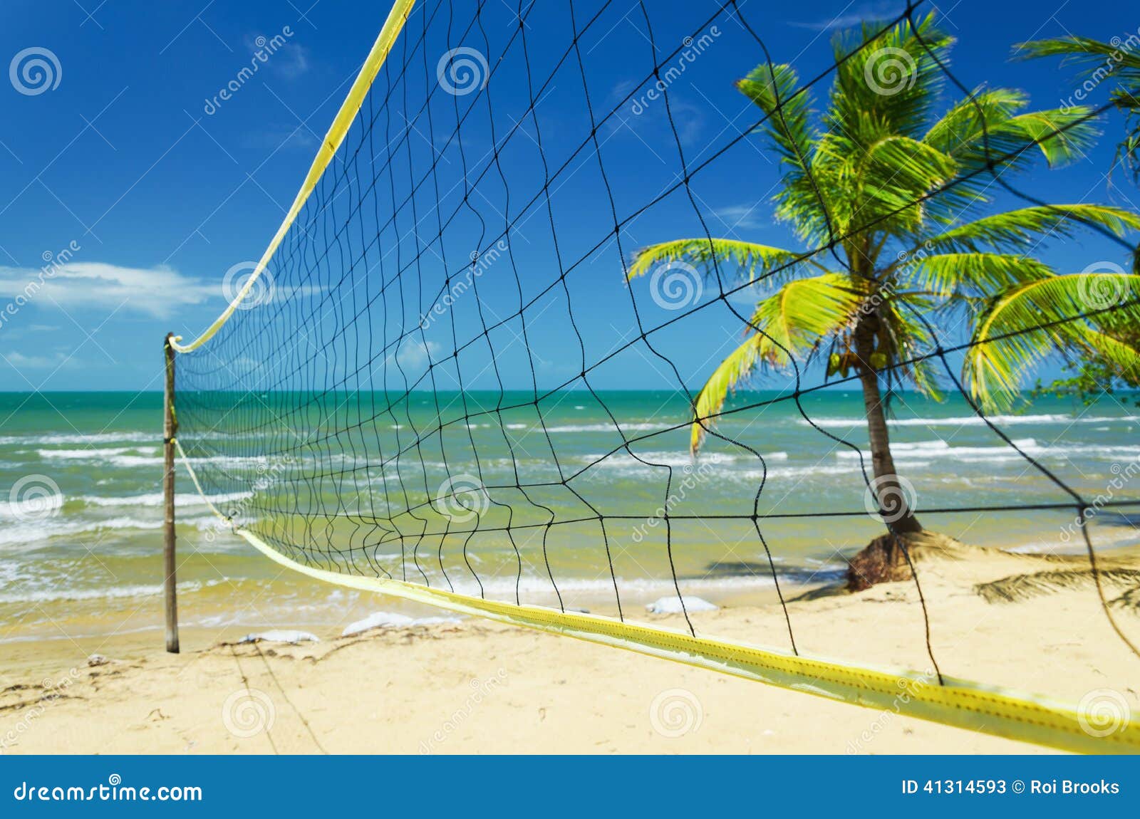 Volleyboll förtjänar på en tropisk strand. En volleybal netto aktivering på en tropisk strand i det karibiskt