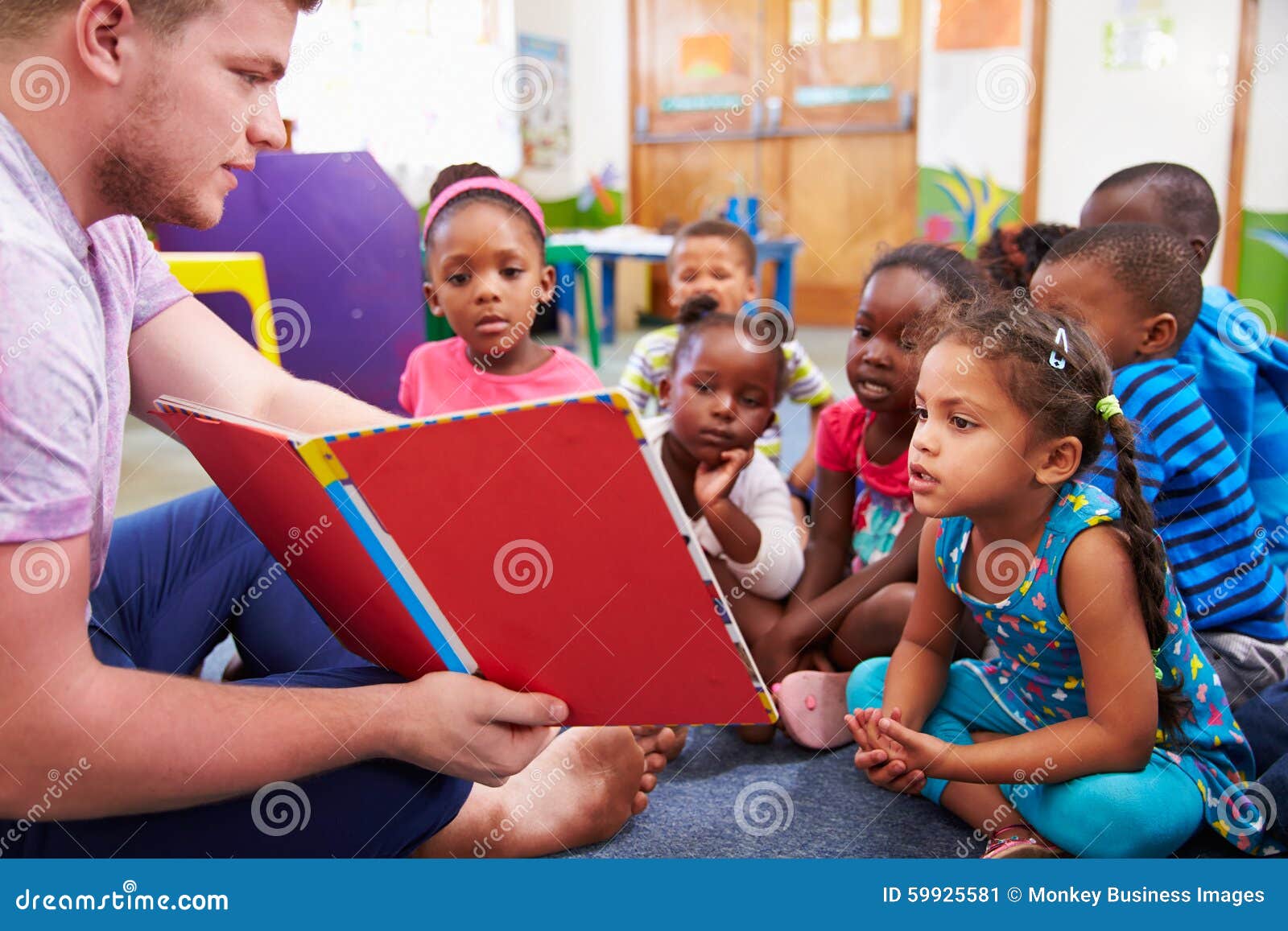 volunteer teacher reading to a class of preschool kids