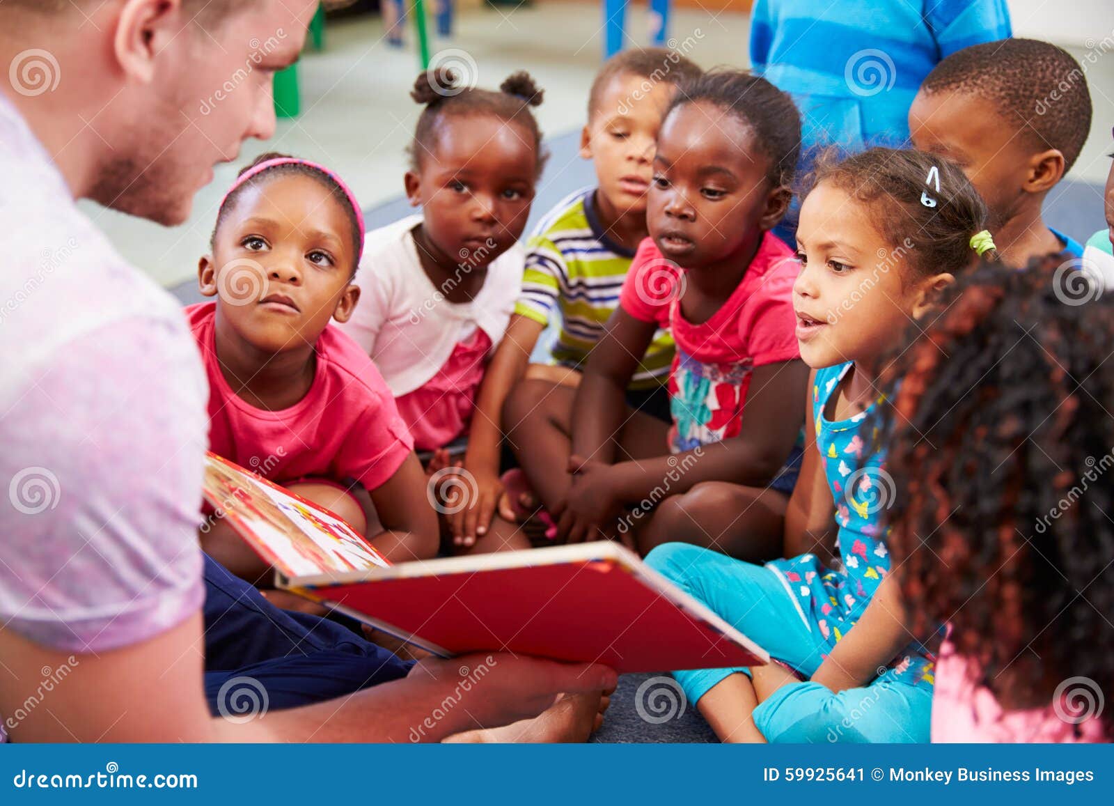 volunteer teacher reading to a class of preschool kids
