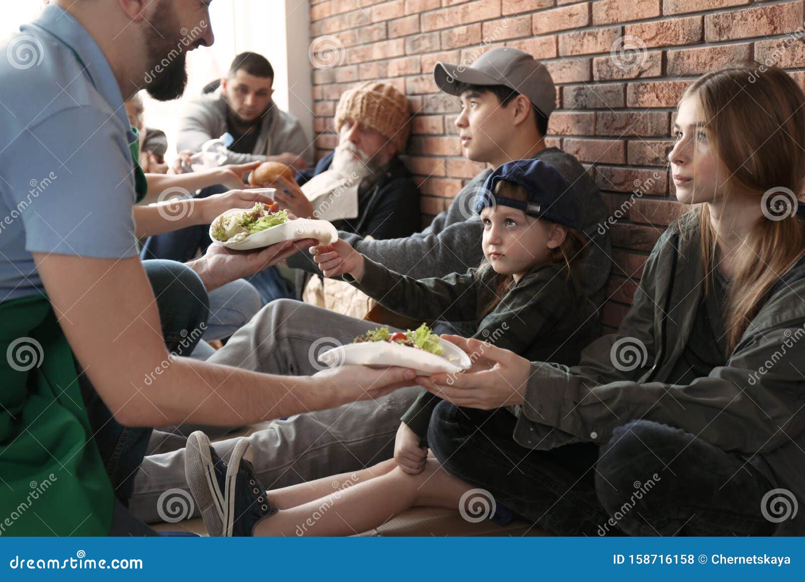 volunteers giving food to poor people