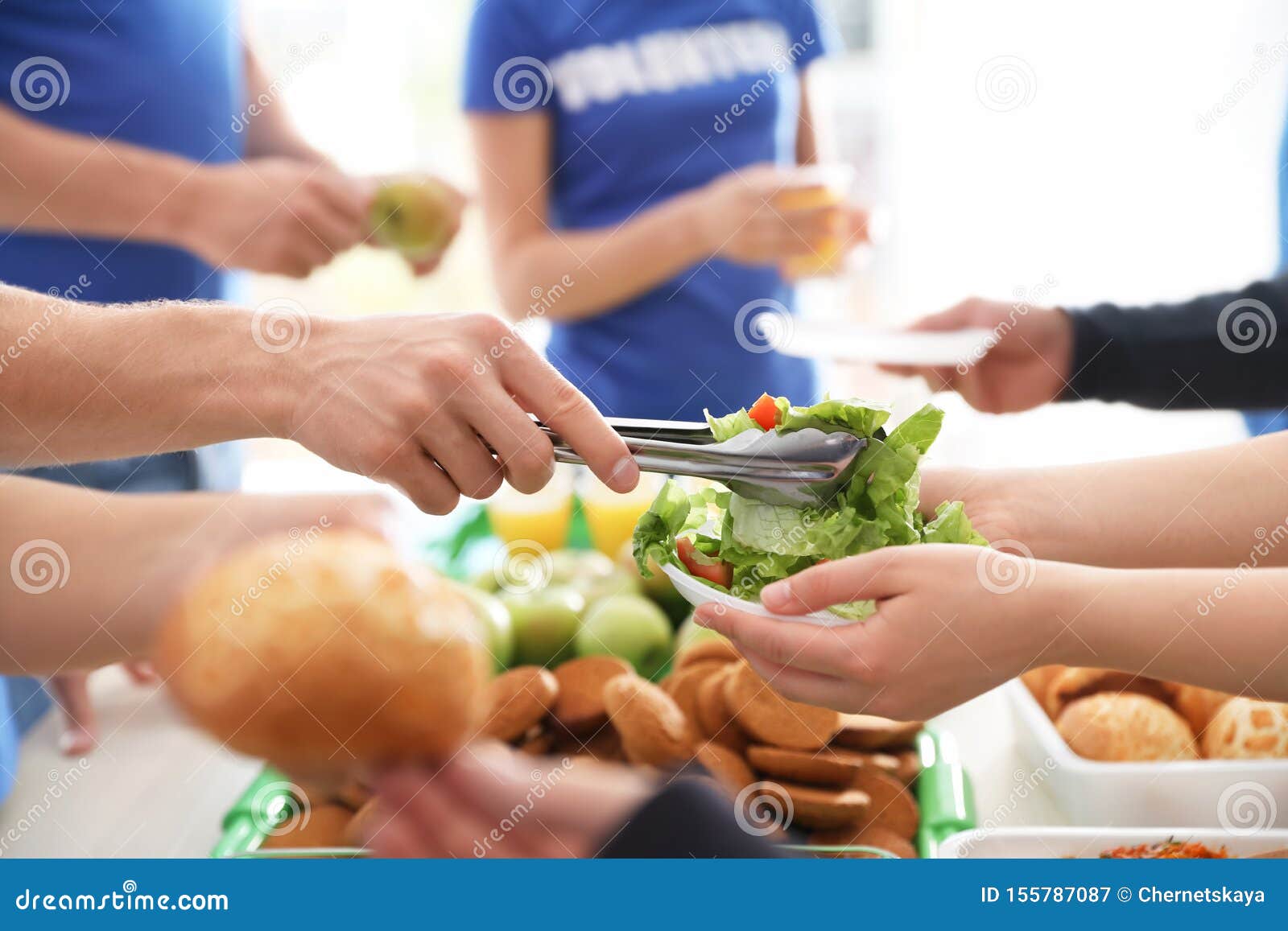 volunteers serving food to poor people,