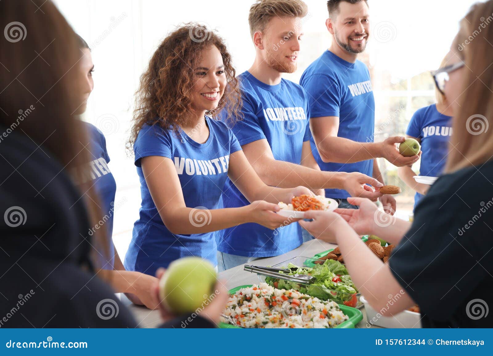 volunteers serving food to poor people