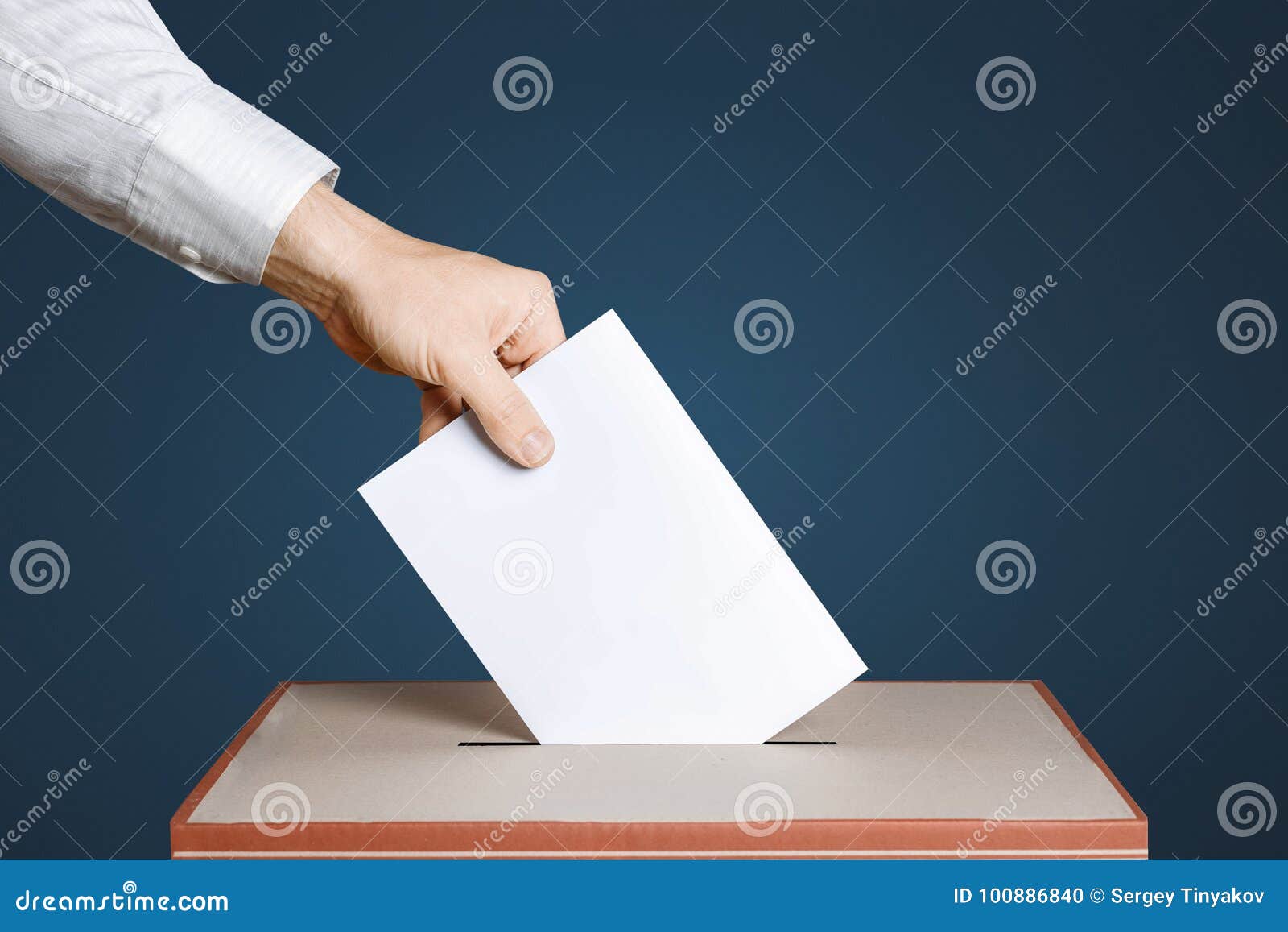 voter holds envelope in hand above vote ballot. blue background. democracy concept