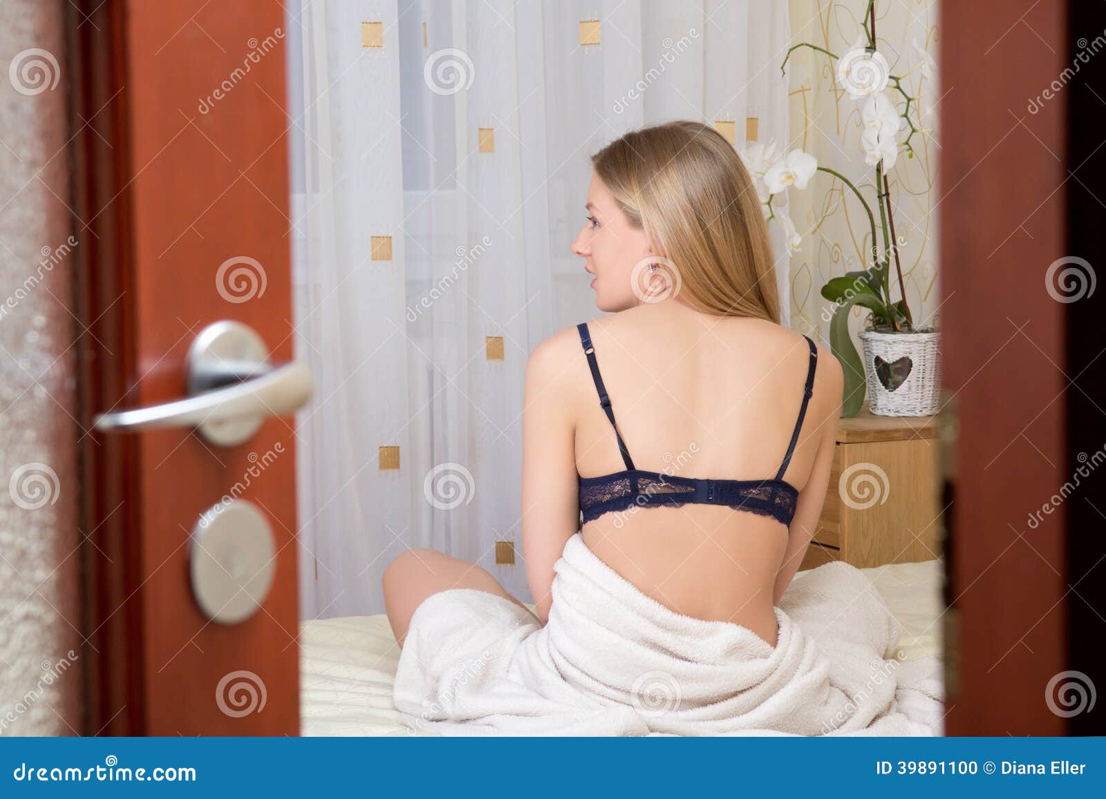 Voyeur Portrait of Young Woman in Lingerie on Bed Stock Photo pic