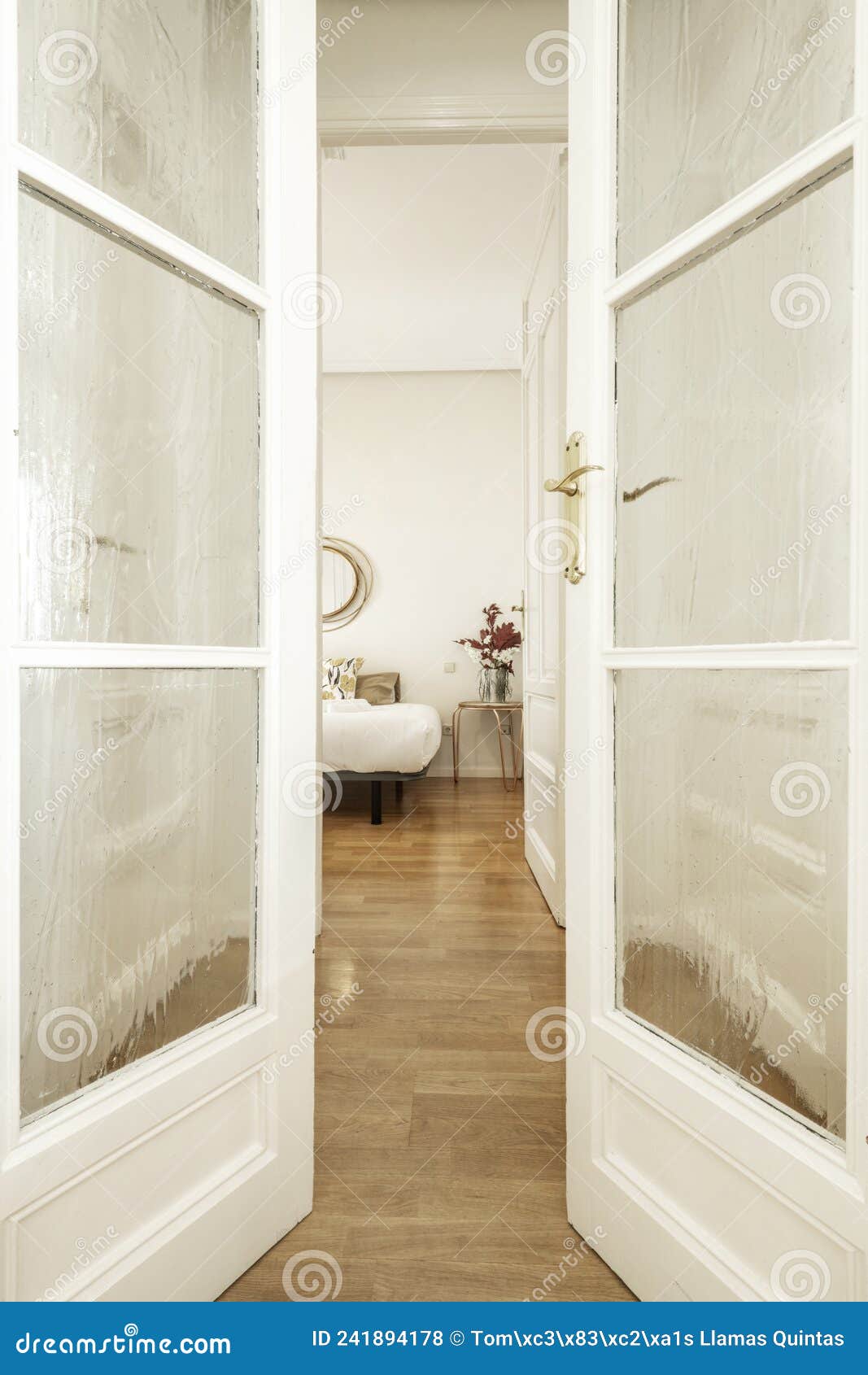 Voyeur View between Wooden and Glass Doors To a Bedroom Stock Photo