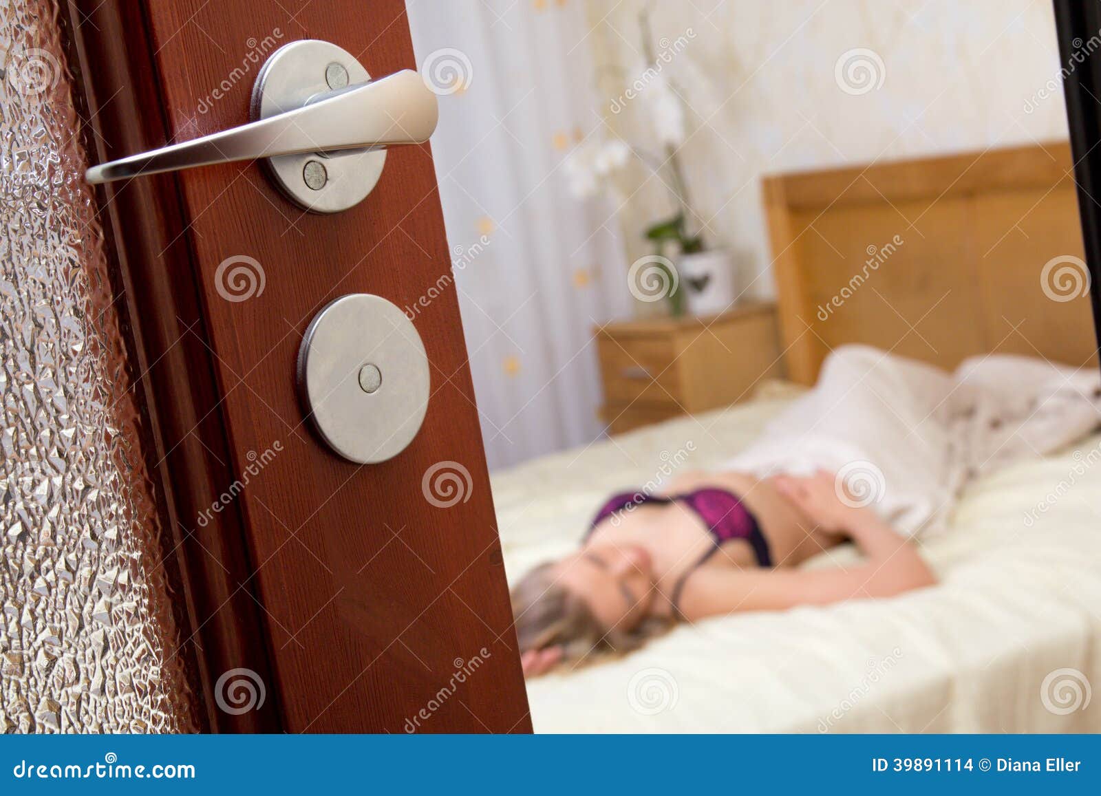 Voyeurism - Woman in Lingerie - View through Bedroom Door Stock Photo picture photo