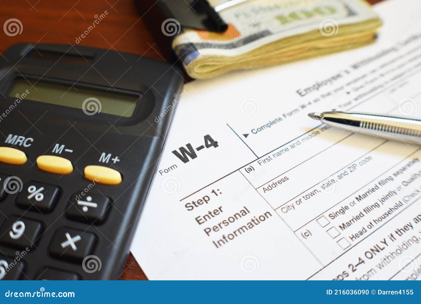 w-4 tax form with pen, calculator and money close up