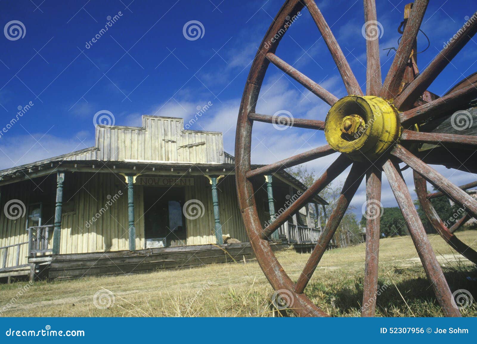 wagon wheel and old building in south tx ghost town