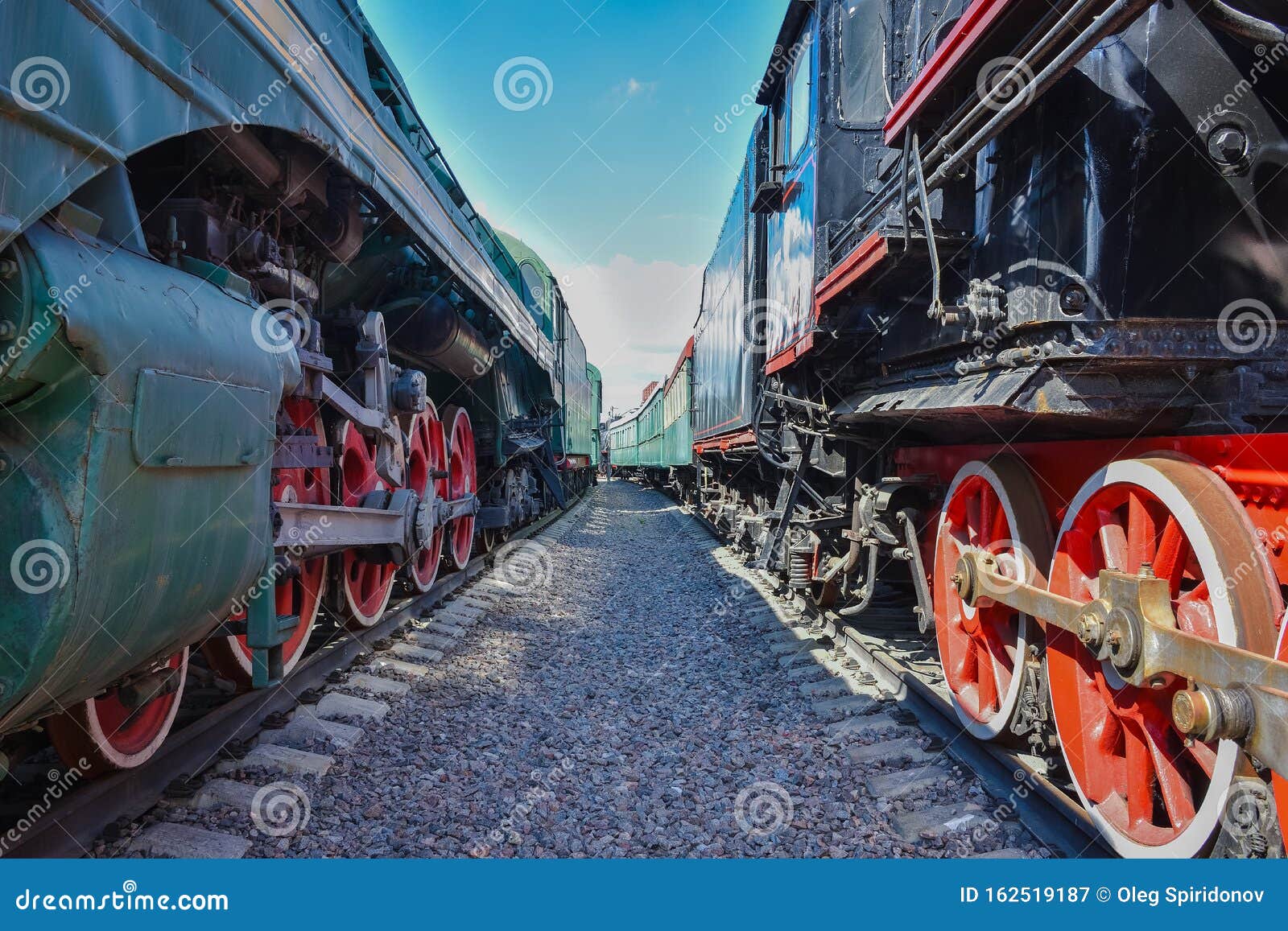 between wagons of old trains, between two old trains, red metal train wheels